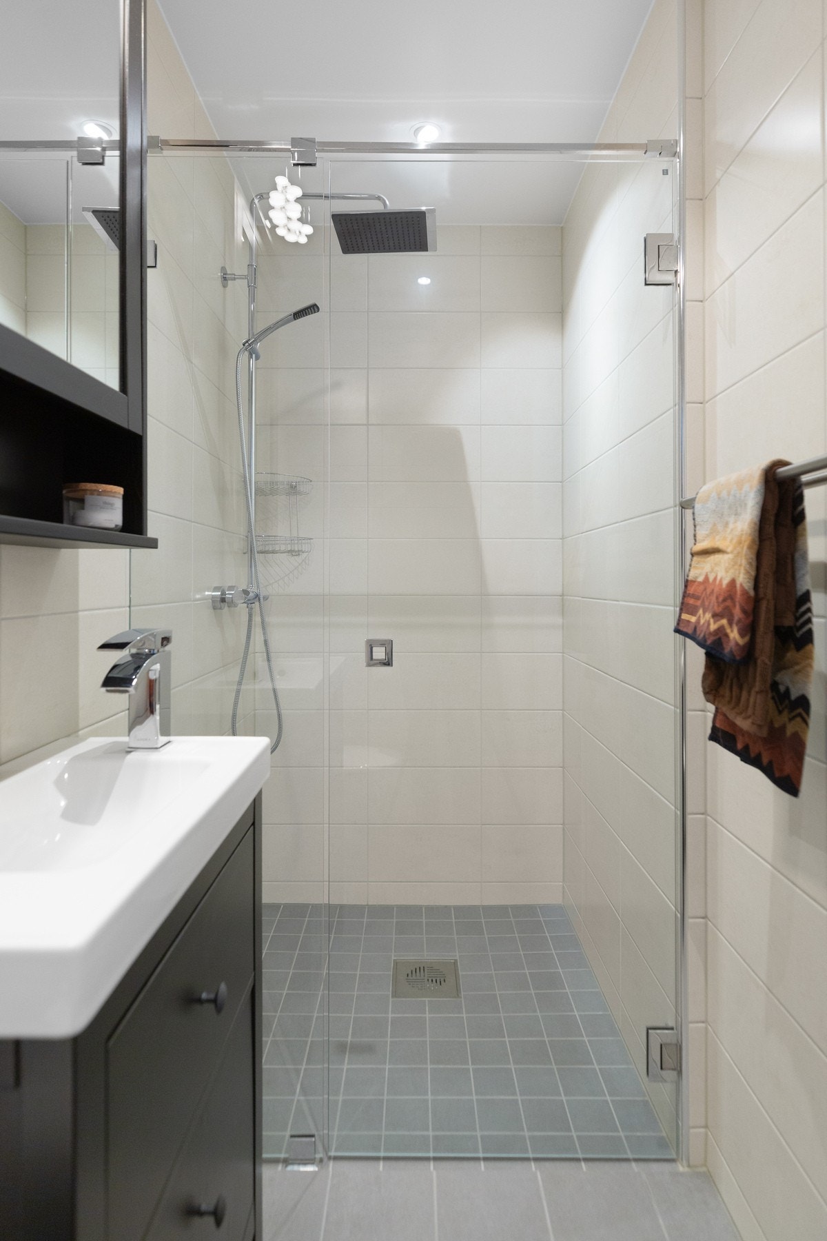 Badet er utstyrt med varme i gulv, servant med innredning, regndusj, dusjdører av glass og vegghengt toalett. Galleribilde