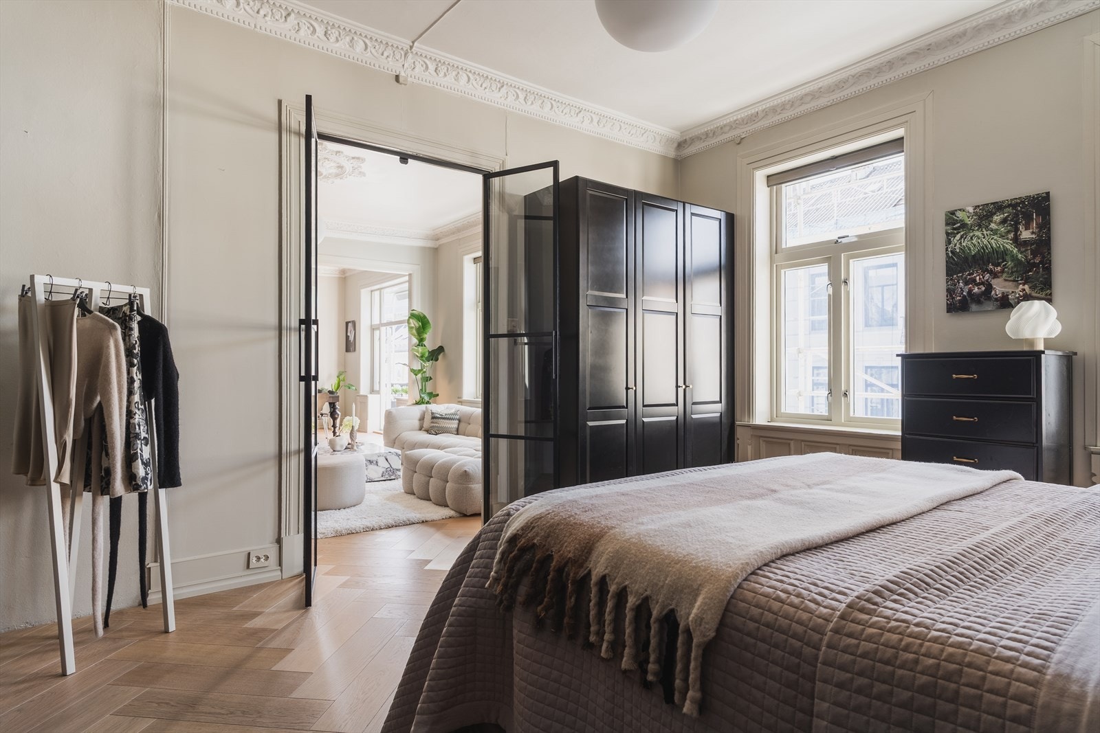 Hellimt eikegulv i fiskebensmønster lagt terskelløst mellom rommene skaper en fin flyt gjennom leiligheten. Galleribilde