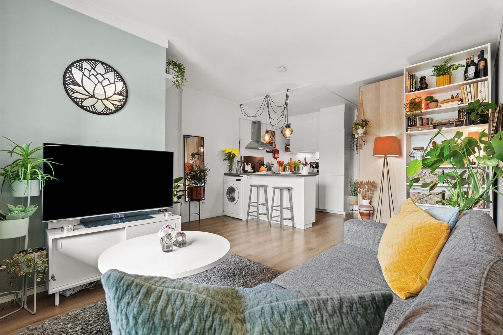 Leiligheten har en åpen og sosial løsning. Det er kun en barløsning som skiller stuen og kjøkkenet fra hverandre. Galleribilde