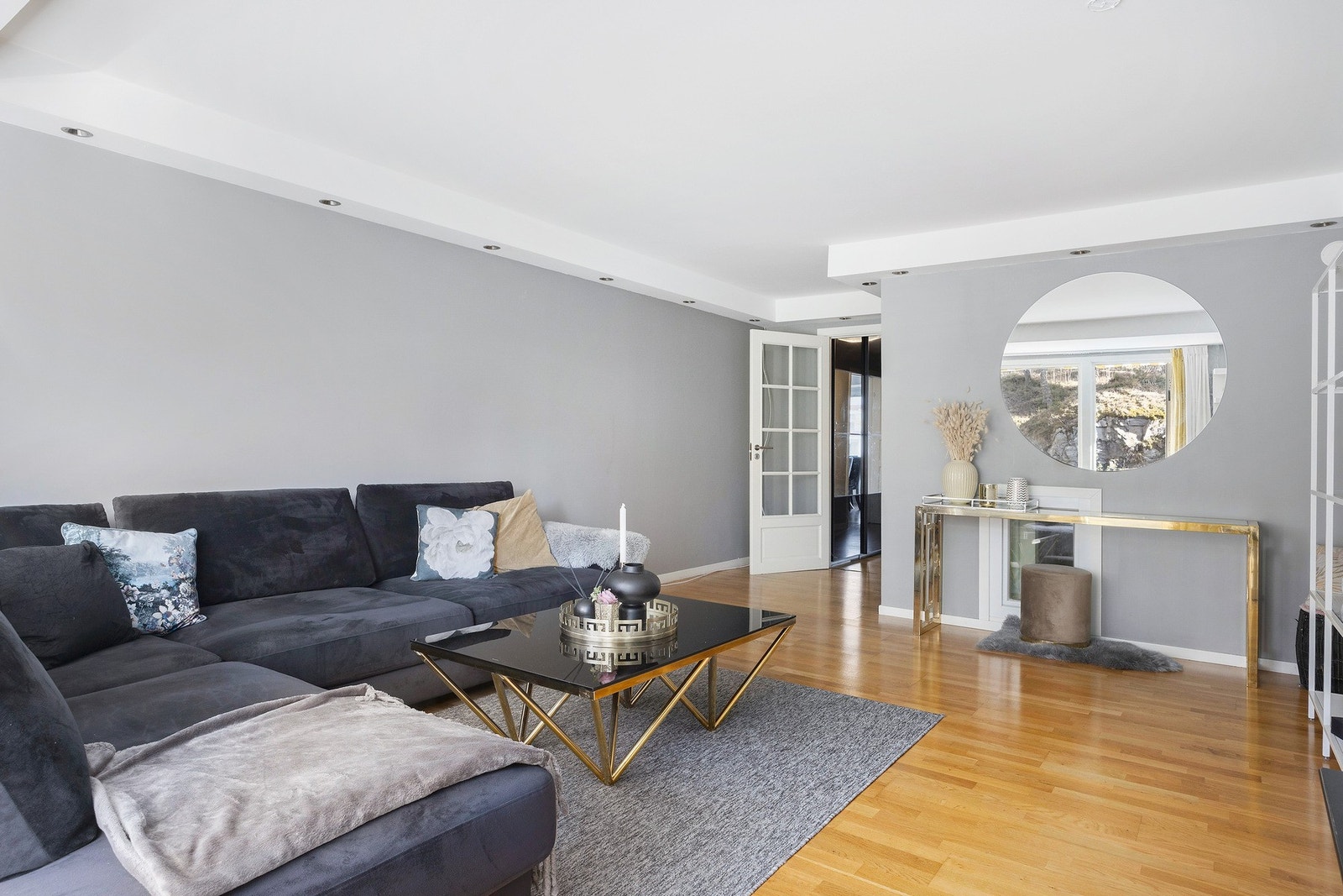 Stuen har en lun atmosfære med gråmalte vegger og spotter i taket som gir et moderne preg. Galleribilde