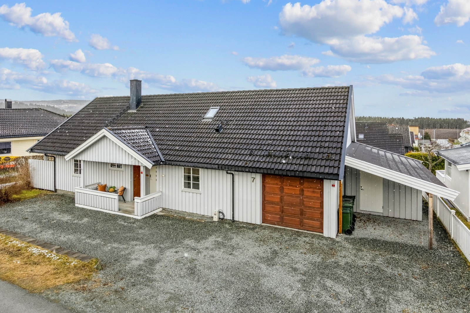 Boligen har integret garasje og stor grusplass for biloppstilling. Galleribilde