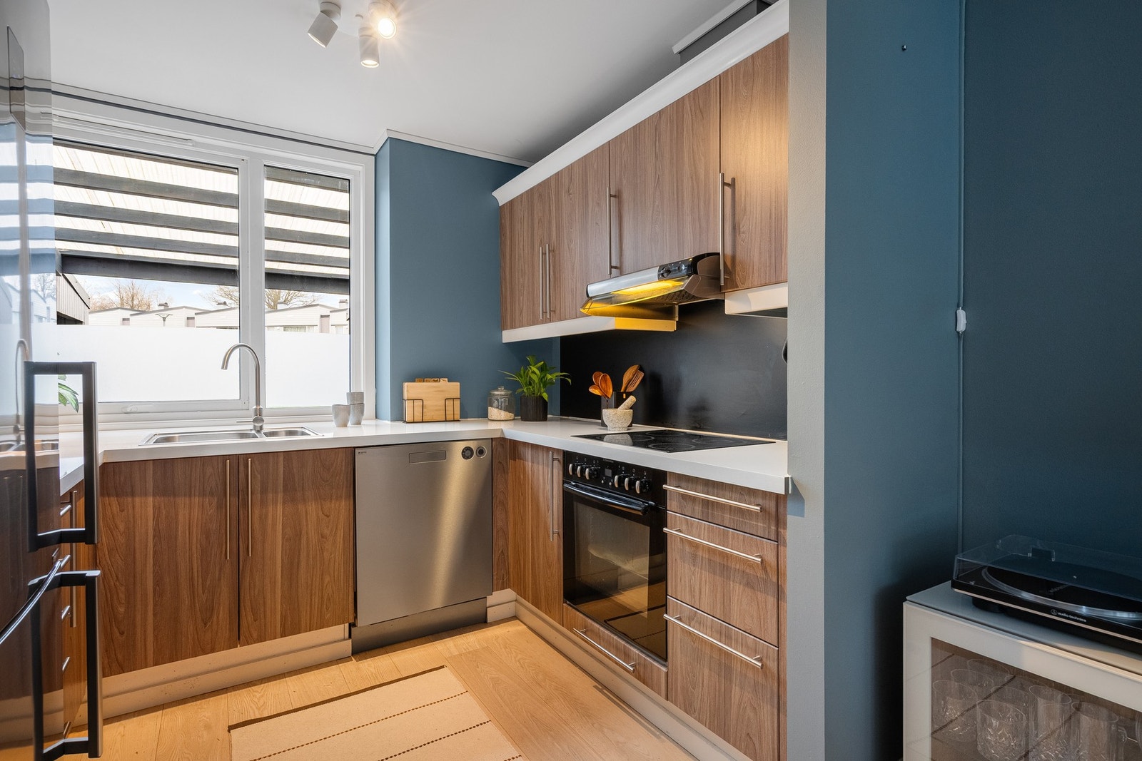 Moderne kjøkken med varme tretoner og godt lysinnslipp. Galleribilde