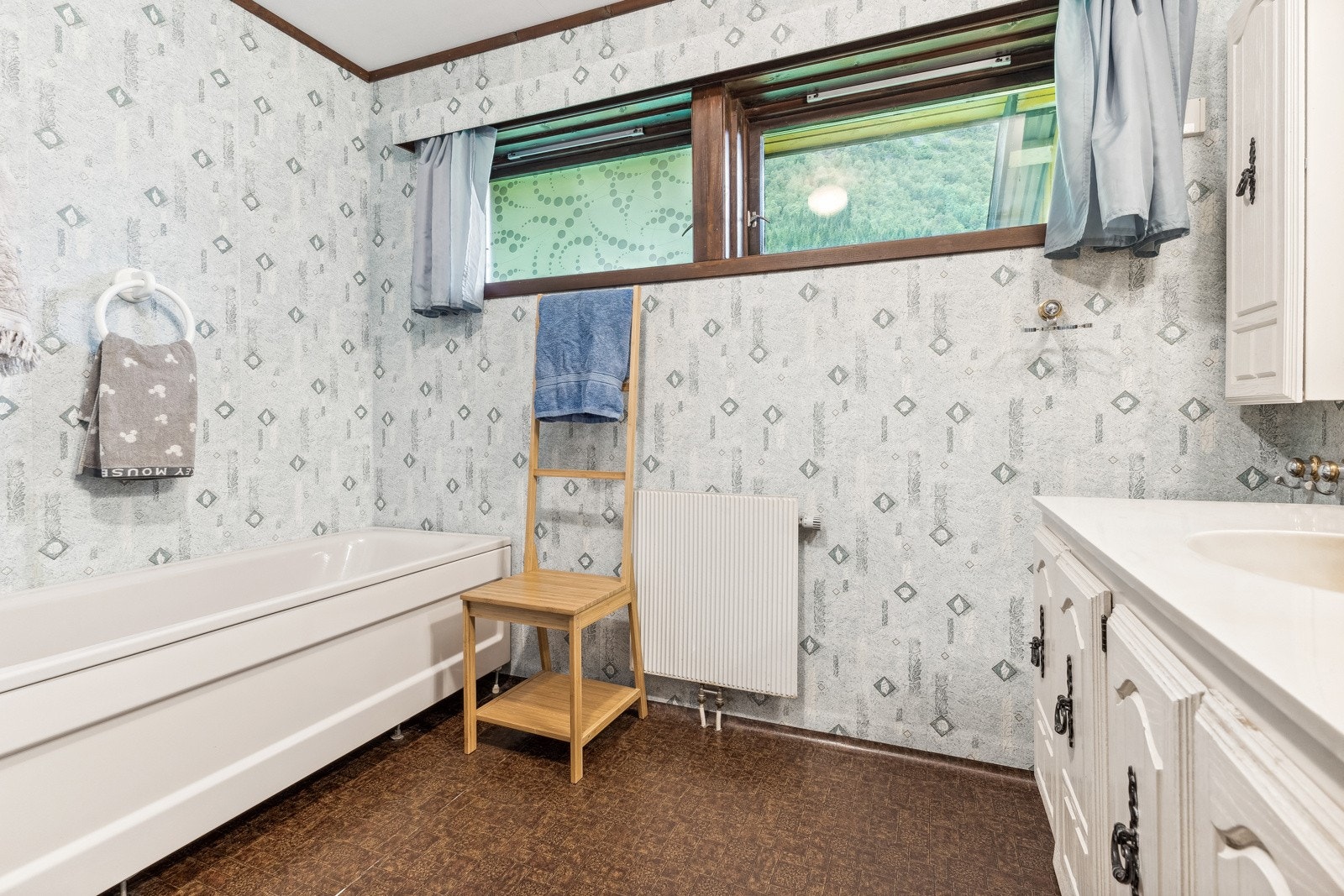 Badet på hovudplan er utstyrt med dusj, badekar, wc og baderomsinnreiing Galleribilde