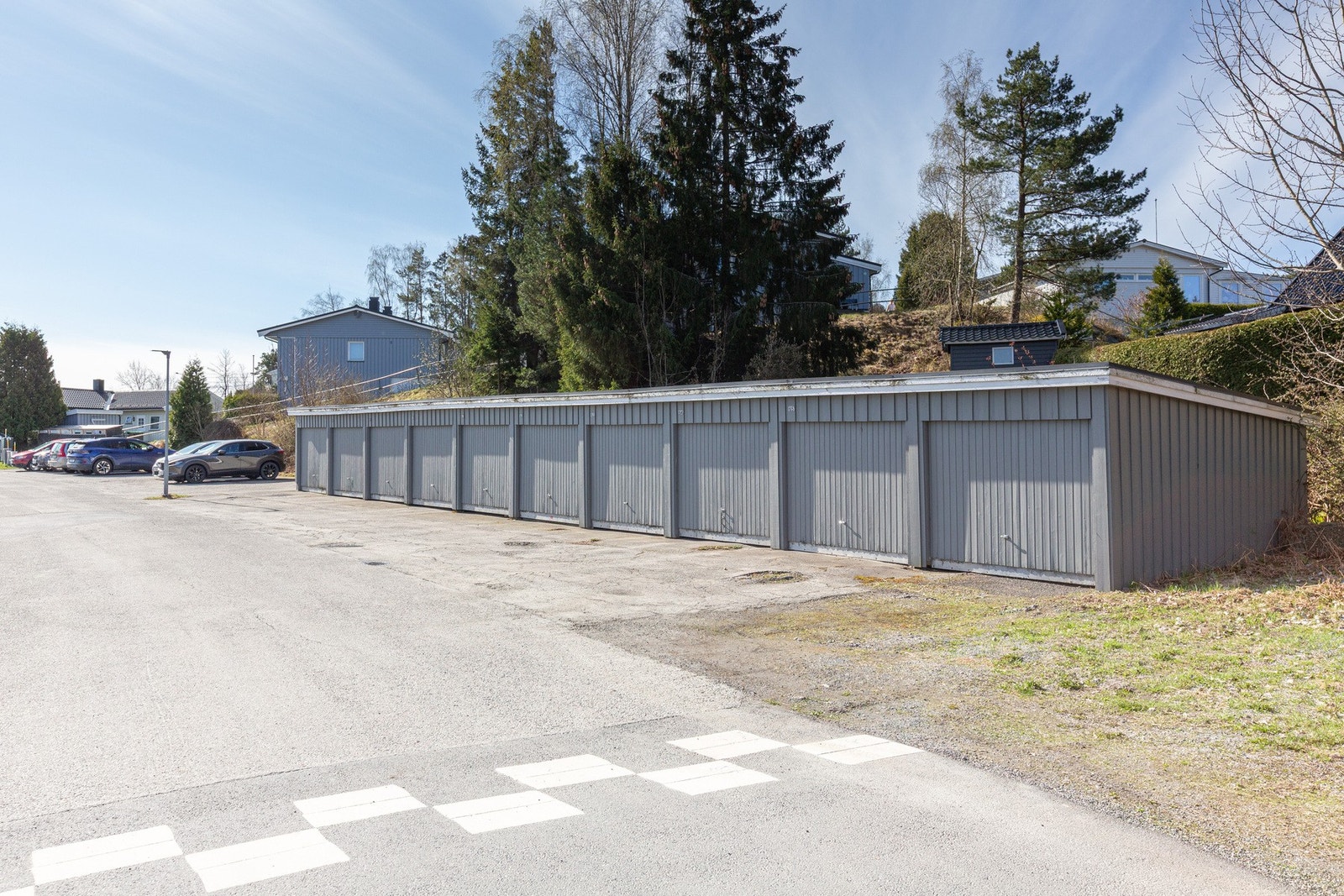 Stor, felles parkeringsplass like nedenfor leiligheten. Det finnes også flere garasjebygg i gaten, hvor man kan stå på venteliste. Galleribilde