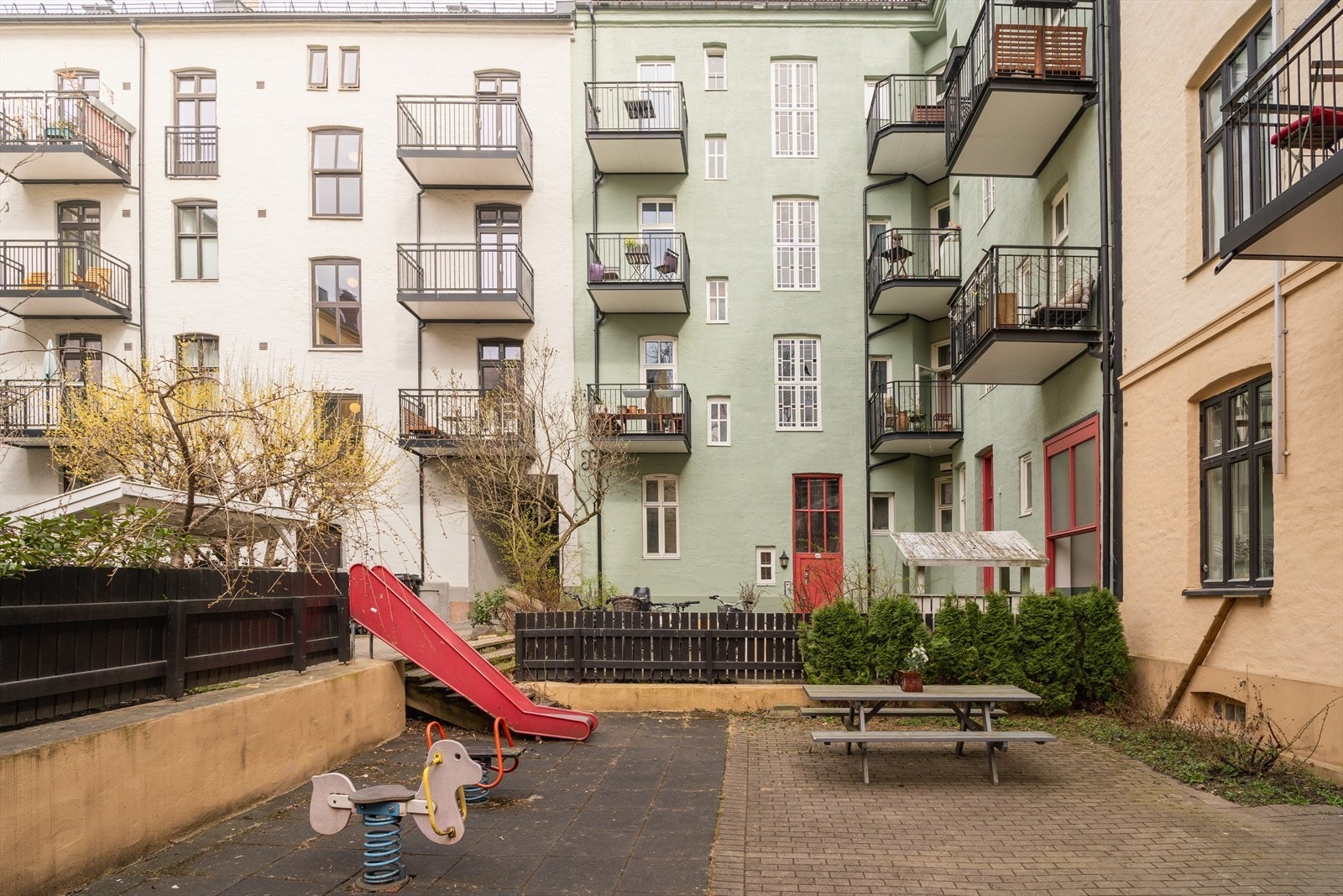 En rekke sittegrupper, lekeapparater, sykkelstativ, osv å benytte seg av i bakgården. Galleribilde