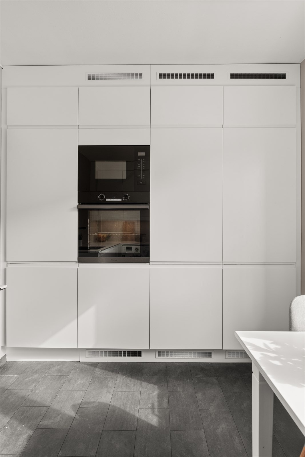 Hvitevarene er sømløst integrert i innredningen og består av induksjonstopp, stekeovn, micro, oppvaskmaskin, kjøleskap og fryseskap. Galleribilde