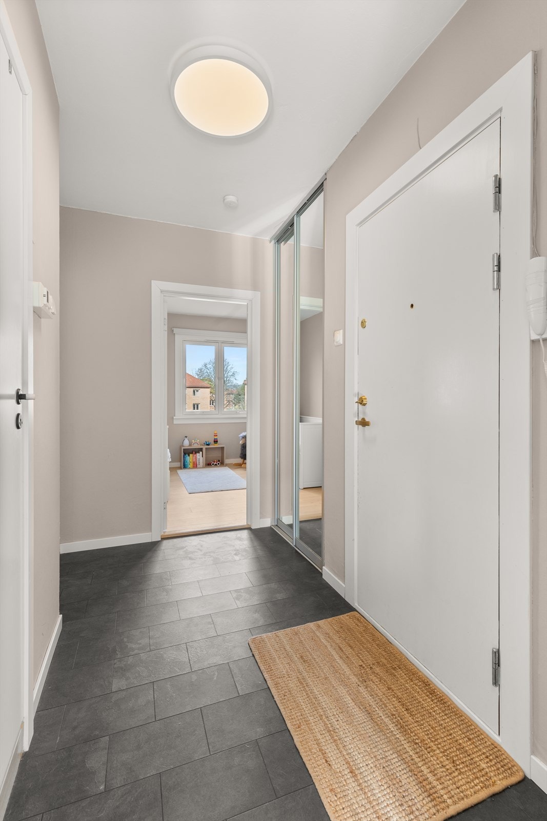 Her er det god plass til å henge fra seg yttertøyet og sette fra seg sko i en praktisk innebygget skyvedørsgarderobe med speilfronter. Galleribilde
