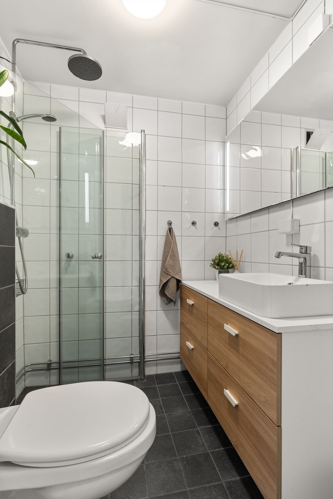 Videre har badet dusjhjørne med svingbare glassdører og vegghengt klosett. Galleribilde