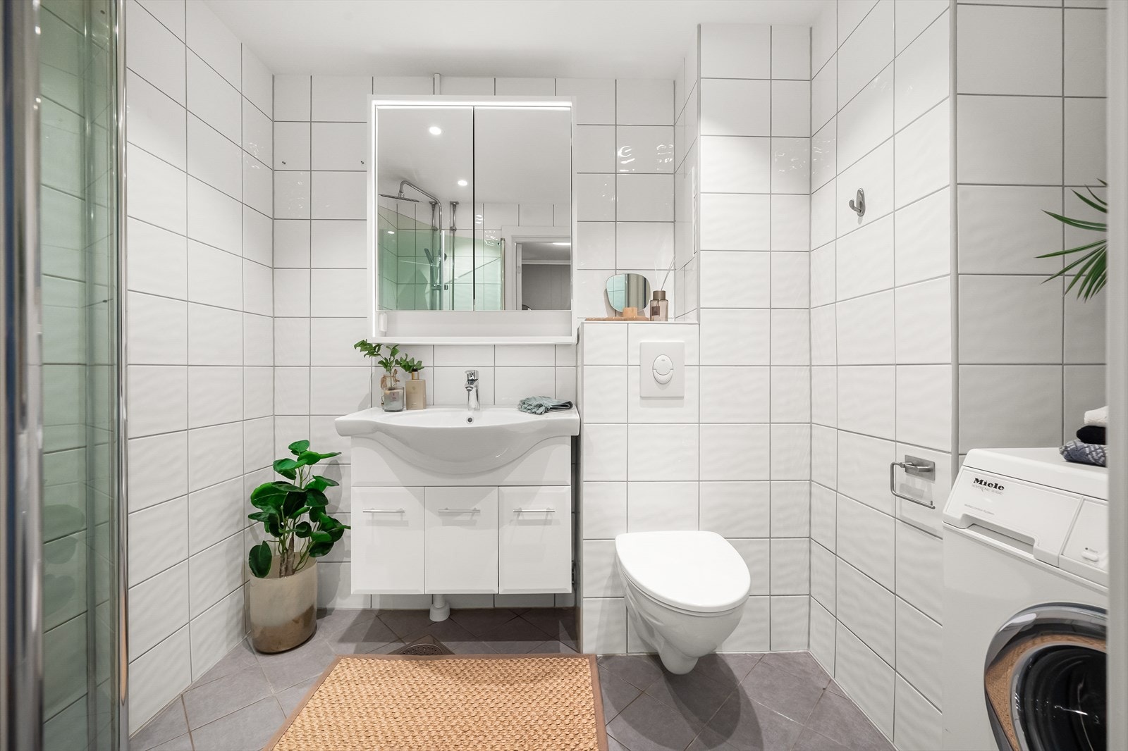 Pent flislagt bad fra 2012 i regi av borettslaget. Badet har varme i gulv, opplegg for vaskemaskin, toalett, speilskap, dusjhjørne og servant med innredning. Nytt speilskap og nye LED downlights fra 2025 Galleribilde