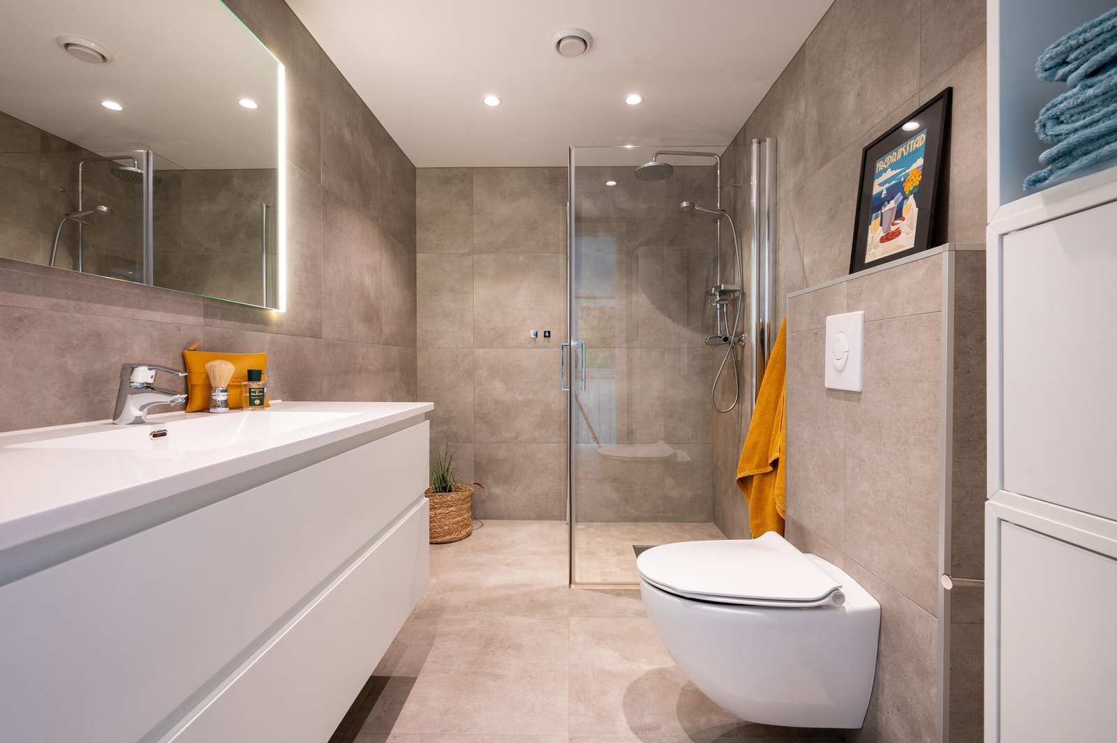 Dette badet er påkostet med store moderne fliser, ekstra innredning og stort speil med lys. Galleribilde