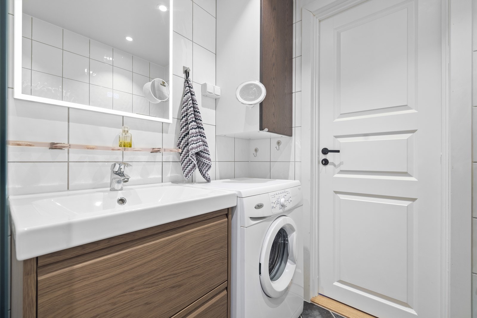 Servantinnredning med god oppbevaringsplass i skuffer, servant med ettgreps blandebatteri, vegghengt skap og speil med integrert belysning. Galleribilde