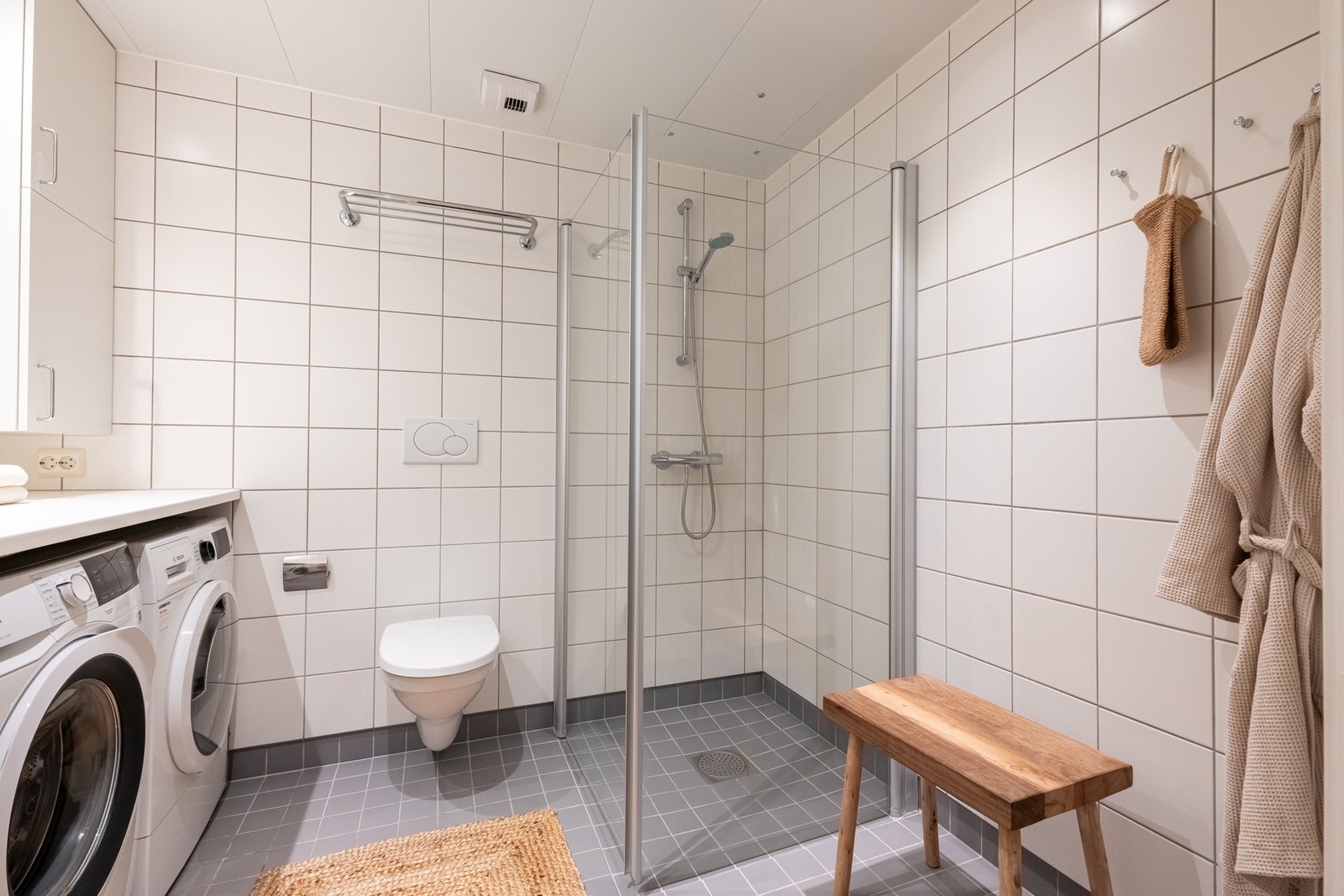 Videre er det vegghengt toalett og dusjhjørne med innfellbar dusjdør som frigjør plass på gulvet. Galleribilde