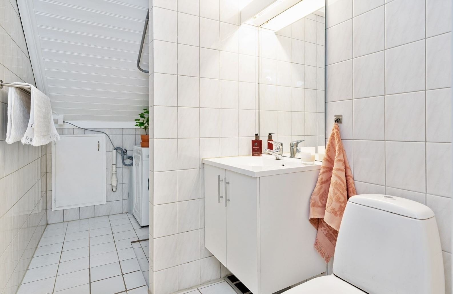 Flislagt baderom med toalett, servant m/innredning, dusj og opplegg for vaskemaskin. Galleribilde