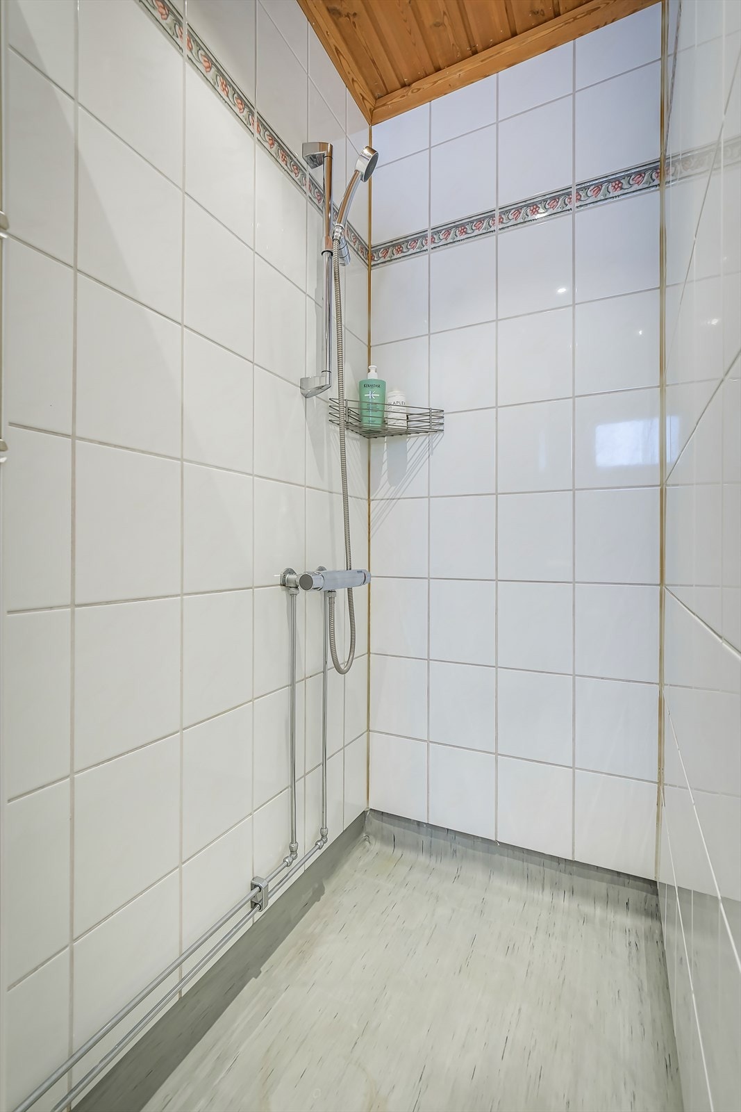 Badet har gulvvarme og utstyrt med toalett, servantskap med blandebatteri og dusjhjørne Galleribilde