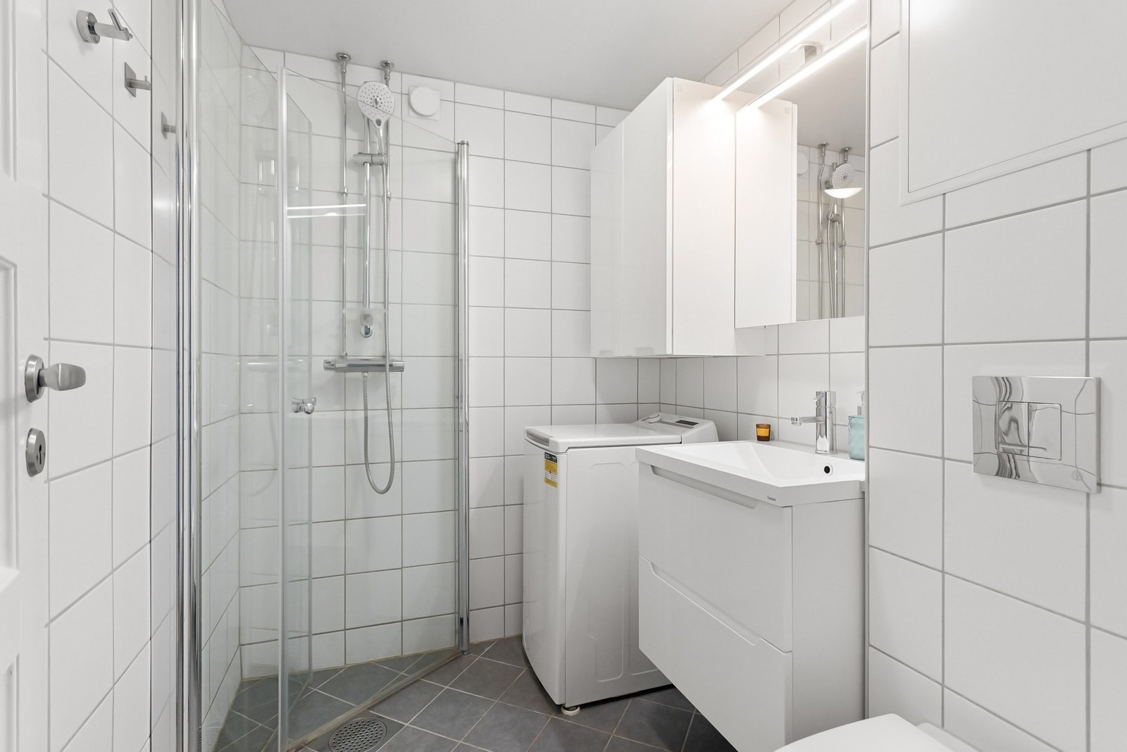 Flislagt baderom med varmekabler i gulv og opplegg for vaskemaskin. Galleribilde