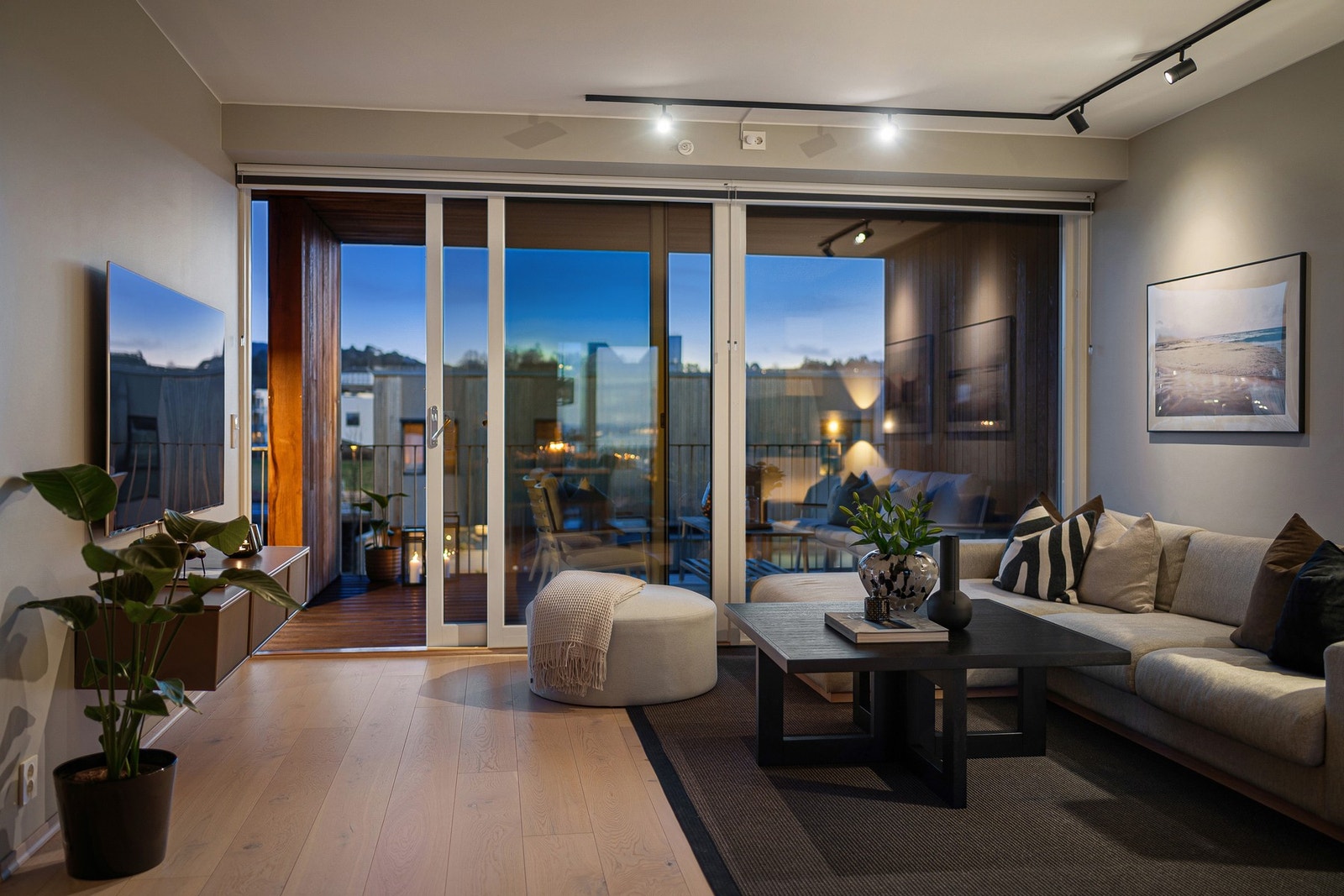 Leiligheten er malt i moderne og dempede fargetoner. Stilige spotter i sort utførelse. Galleribilde