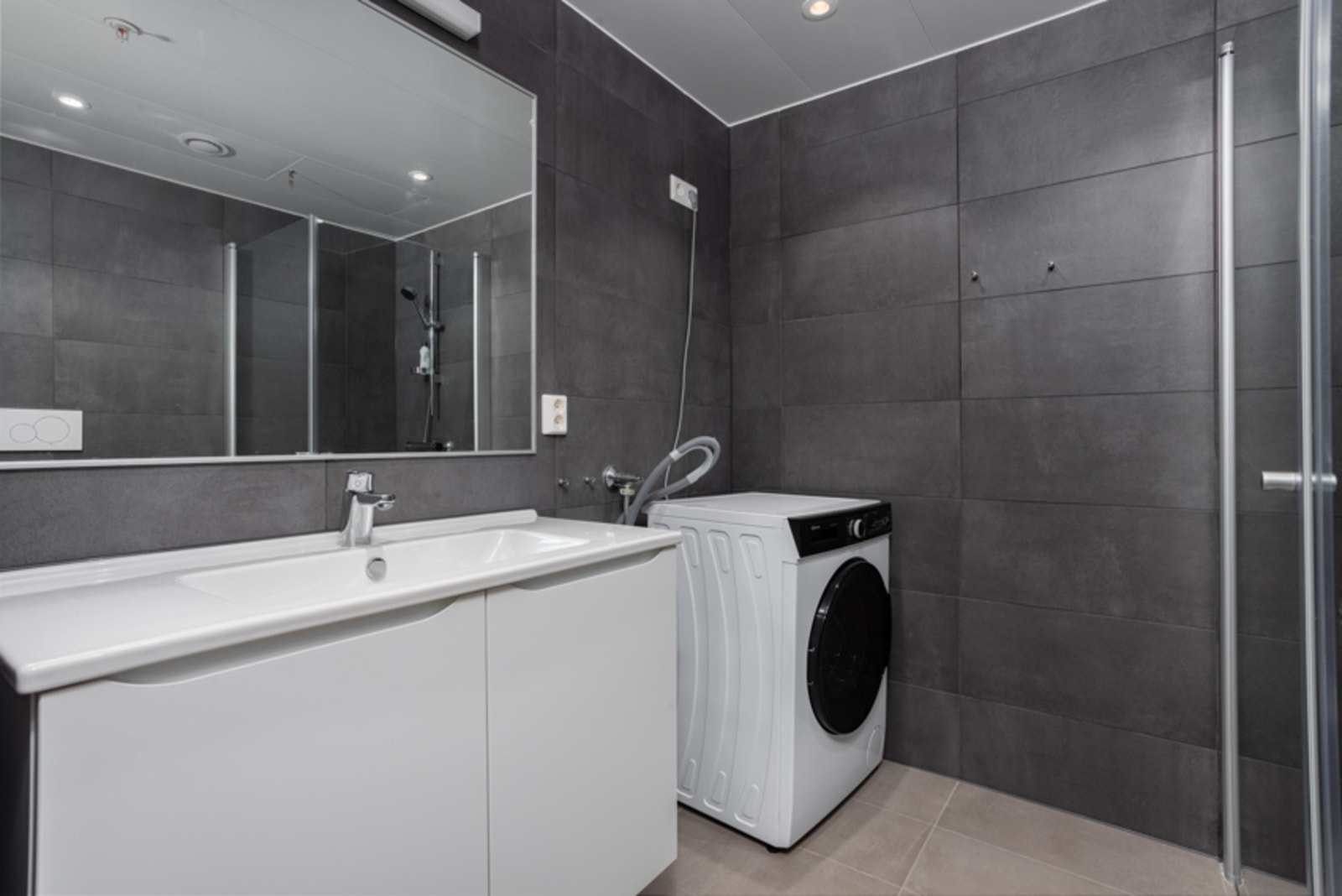 Utstyrt med vegghengt toalett, servant, dusjhjørne og opplegg for vaskemaskin. Galleribilde