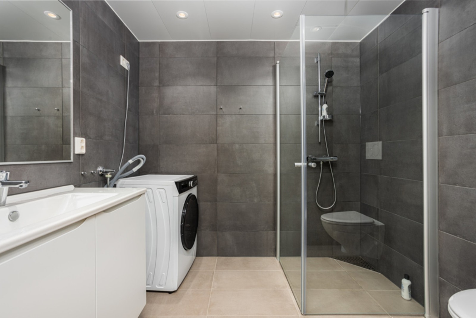 Det flislagte badet avgir en behagelig atmosfære med spotter og varme i gulv. Galleribilde