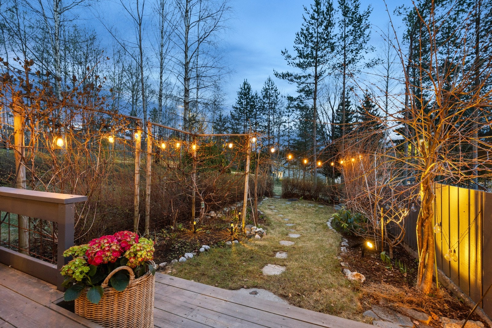 Frodig og pent opparbeidet hage med flere steinbed, blomster og beplantning. Galleribilde