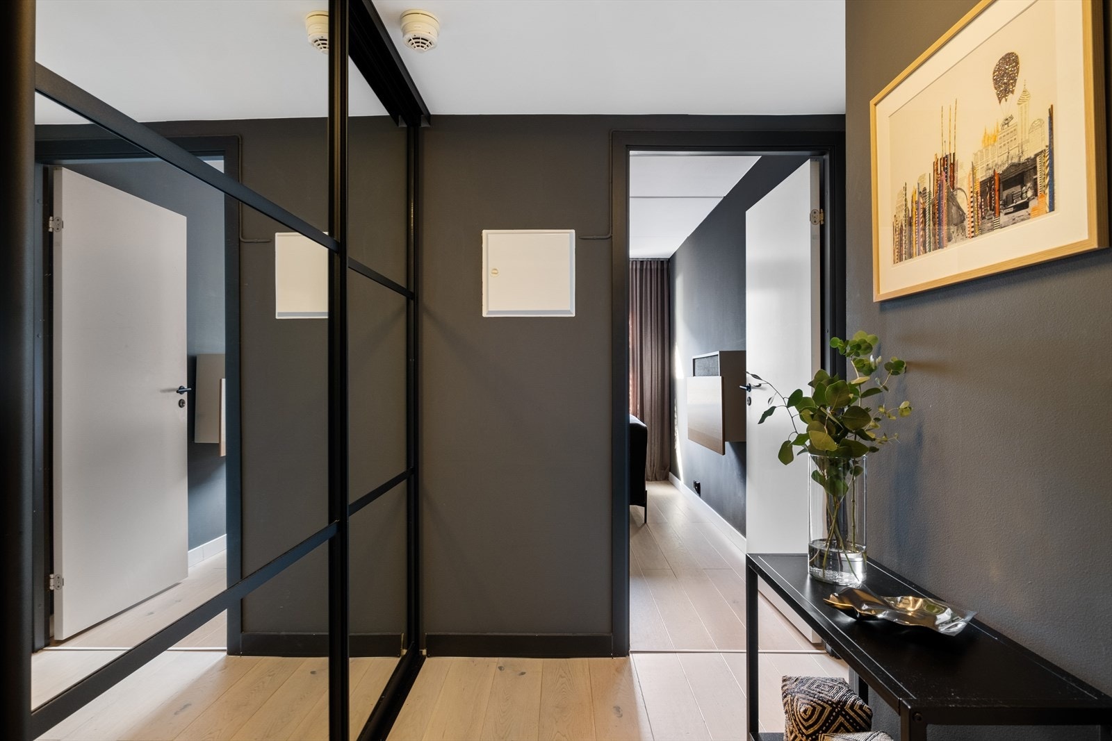 Velkommen inn - Moderne entrè med mørke, elegante vegger og gjennomført stil. Skyvedørsgarderobe fra 2019 med god plass til oppbevaring av sko og yttertøy. Galleribilde