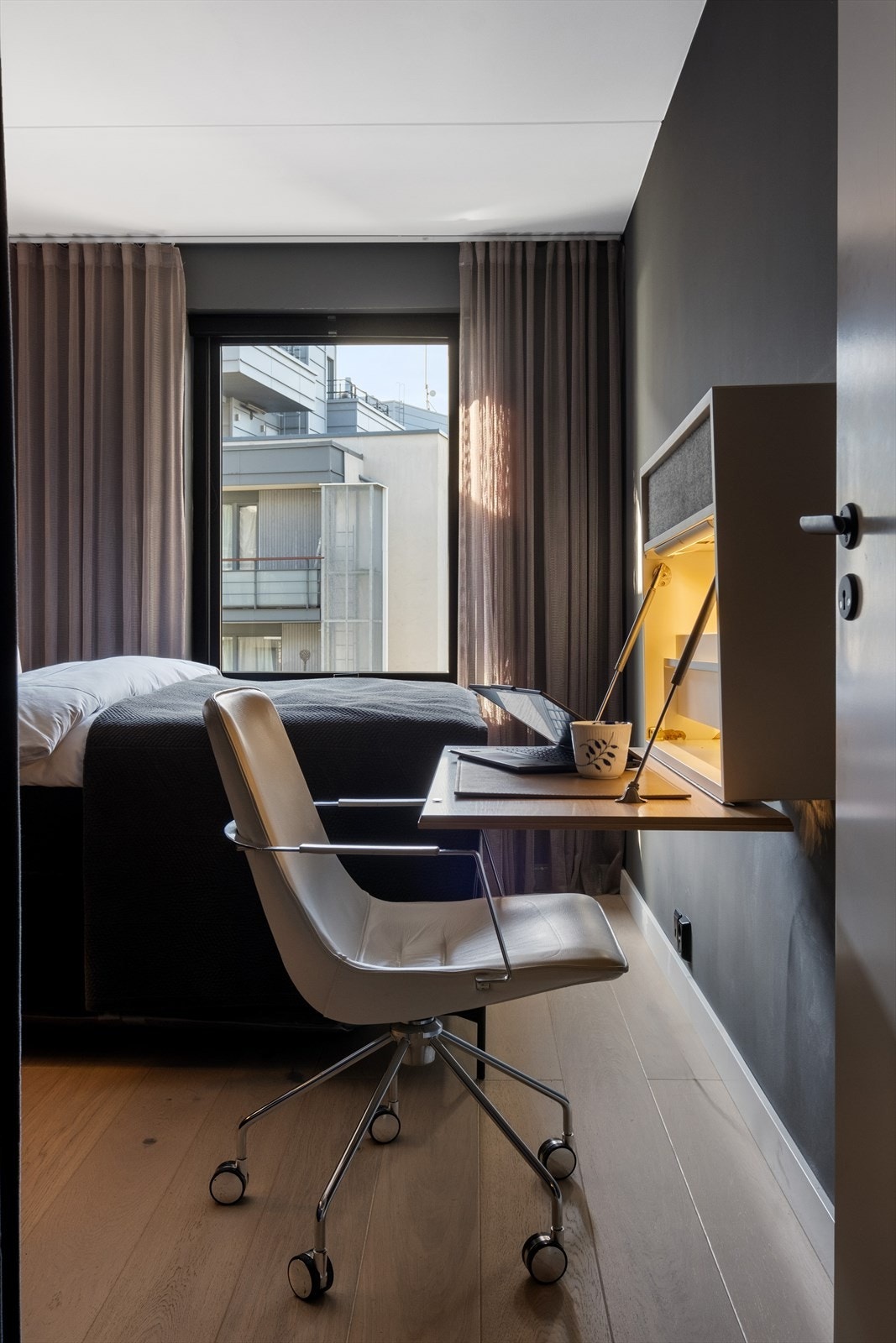 Smarte løsninger for hjemmekontor med plassbygd skrivebord montert på veggen. Galleribilde