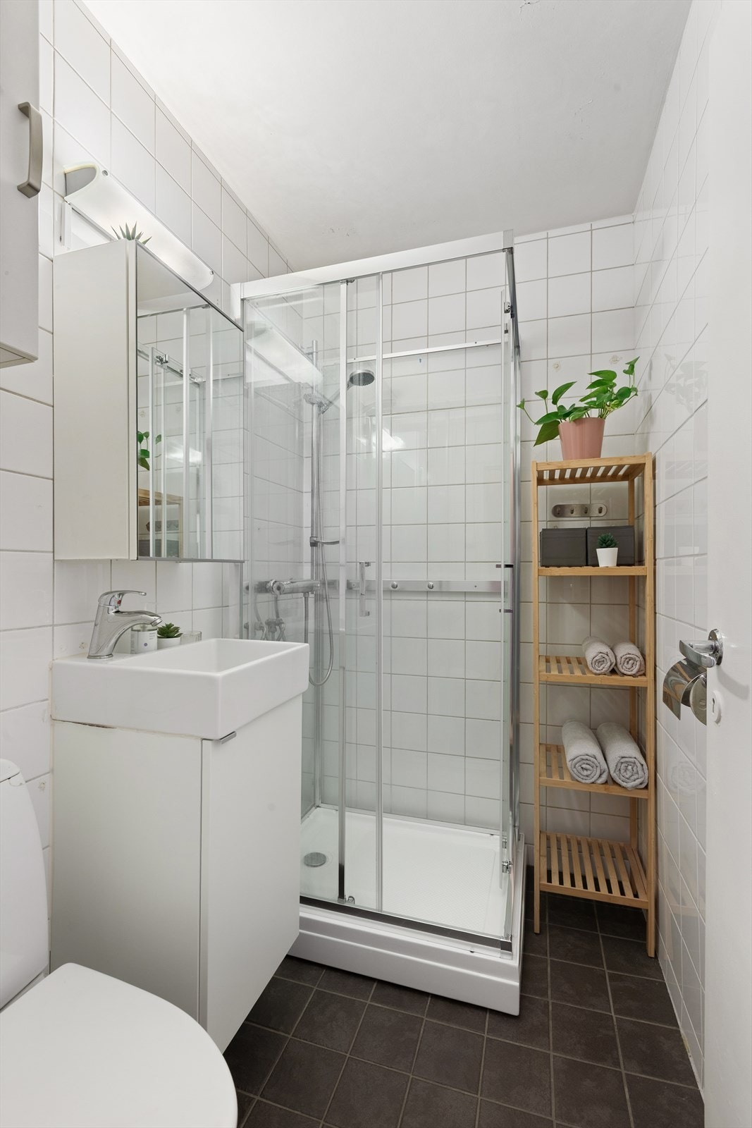 Flislagt bad med dusjkabinett, wc, servant med underskap og speilskap. Galleribilde