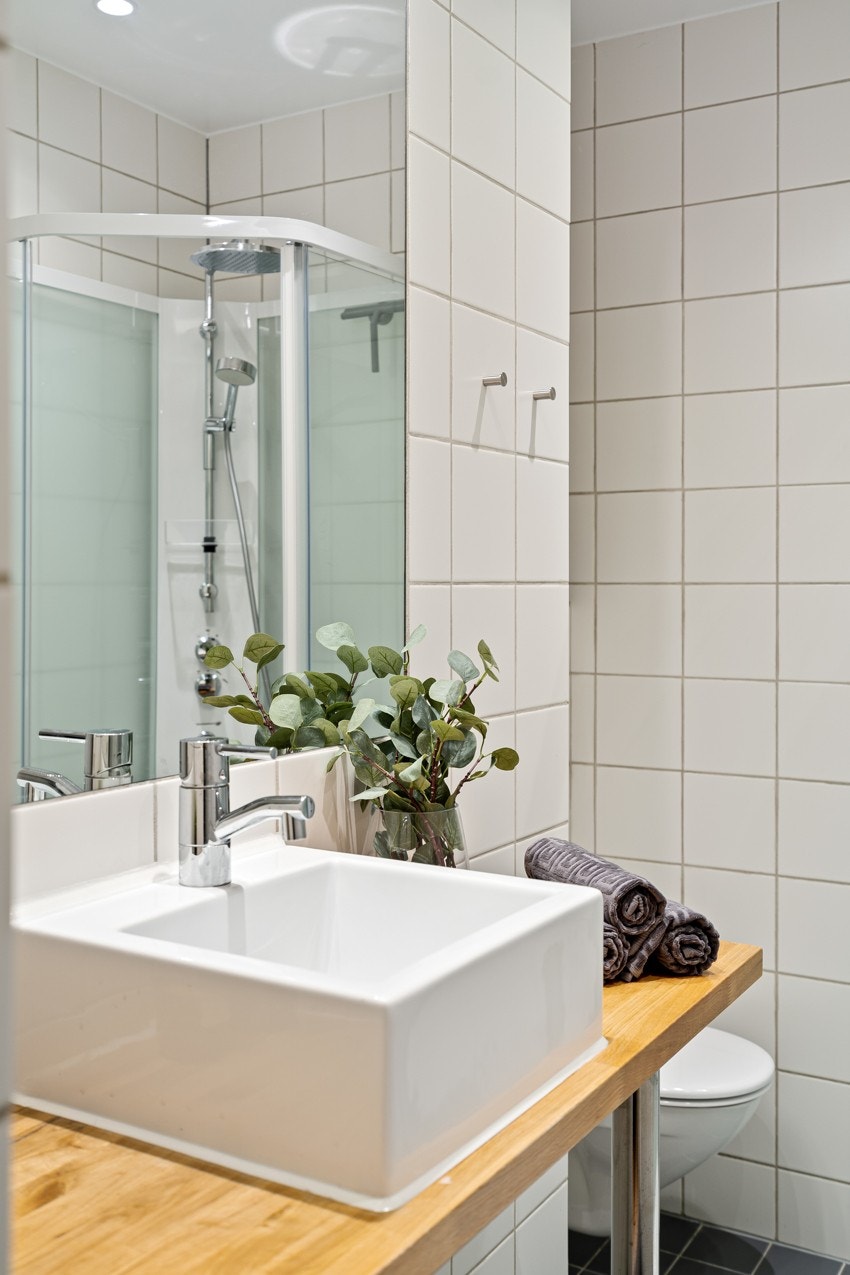 Rommet har Benkeplate i heltre, servant, veggmontert toalett og dusjkabinett. Galleribilde