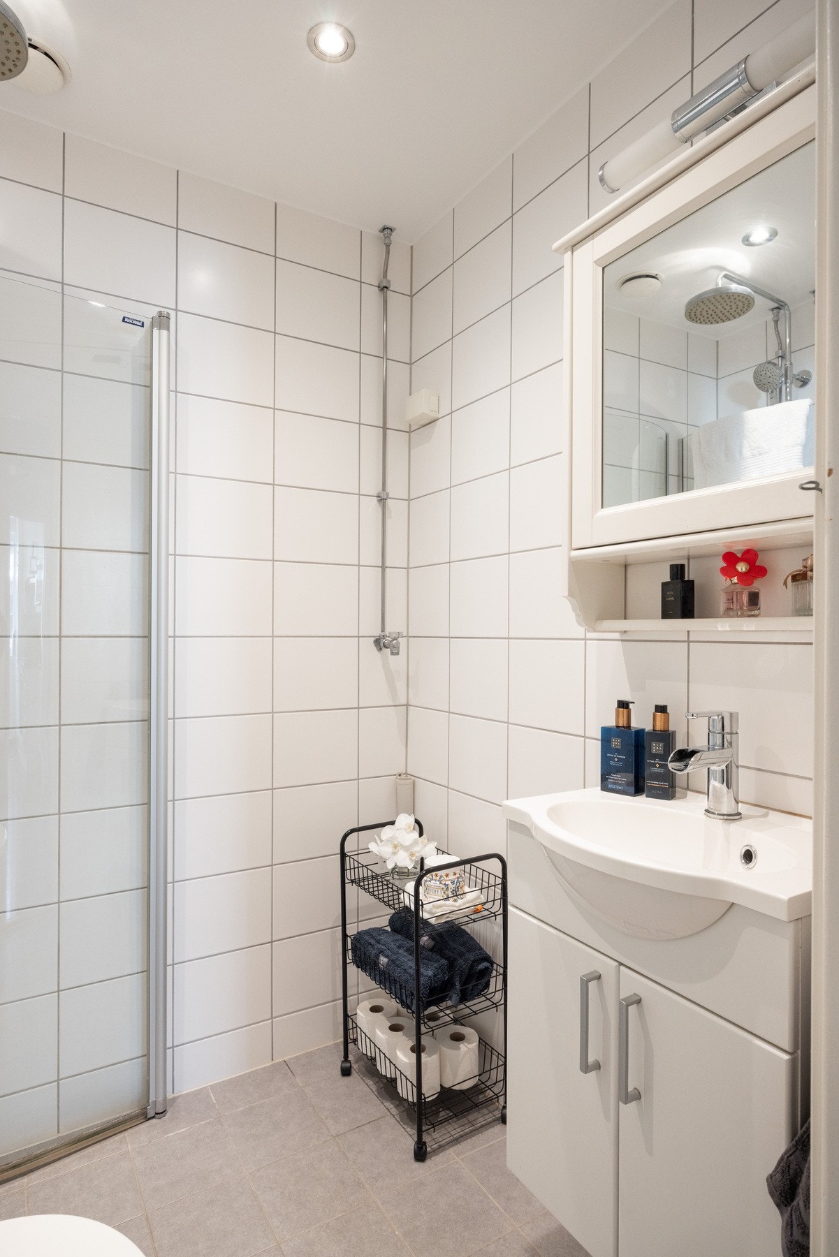 Badet er innredet med servantskap, vegghengt toalett og dusjhjørne med innfellbare dusjdører. Galleribilde