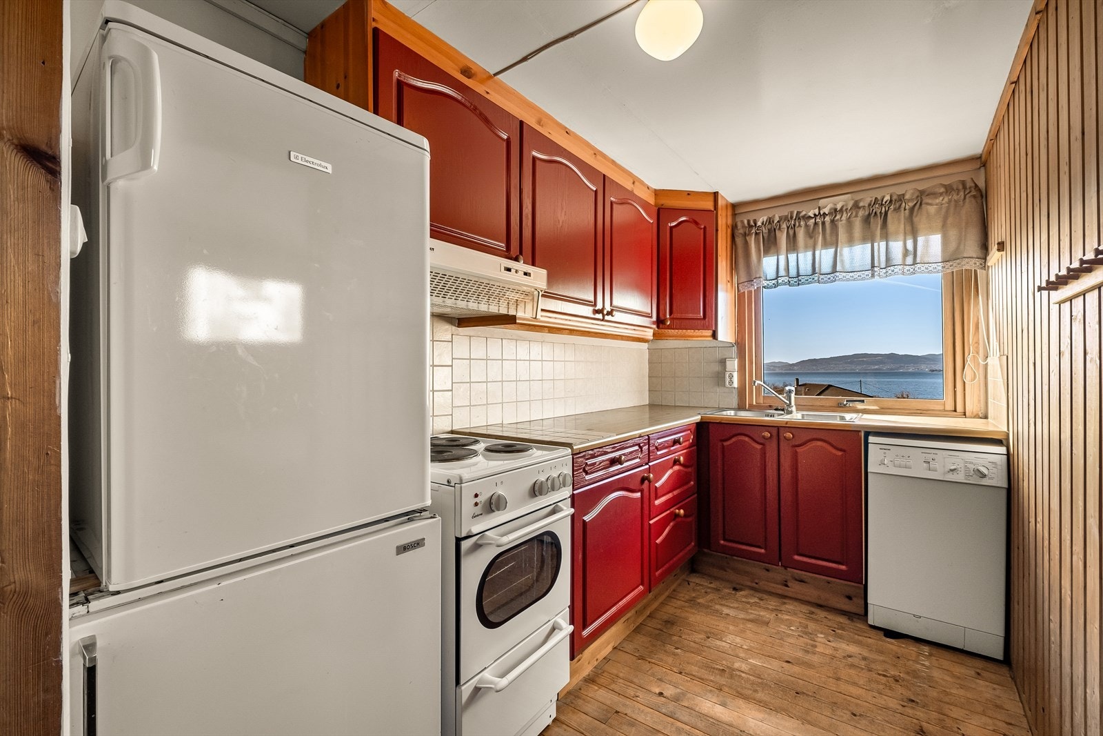 Kjøkkenet er innredet med profilerte malte fronter og benkeplate av laminat. Galleribilde