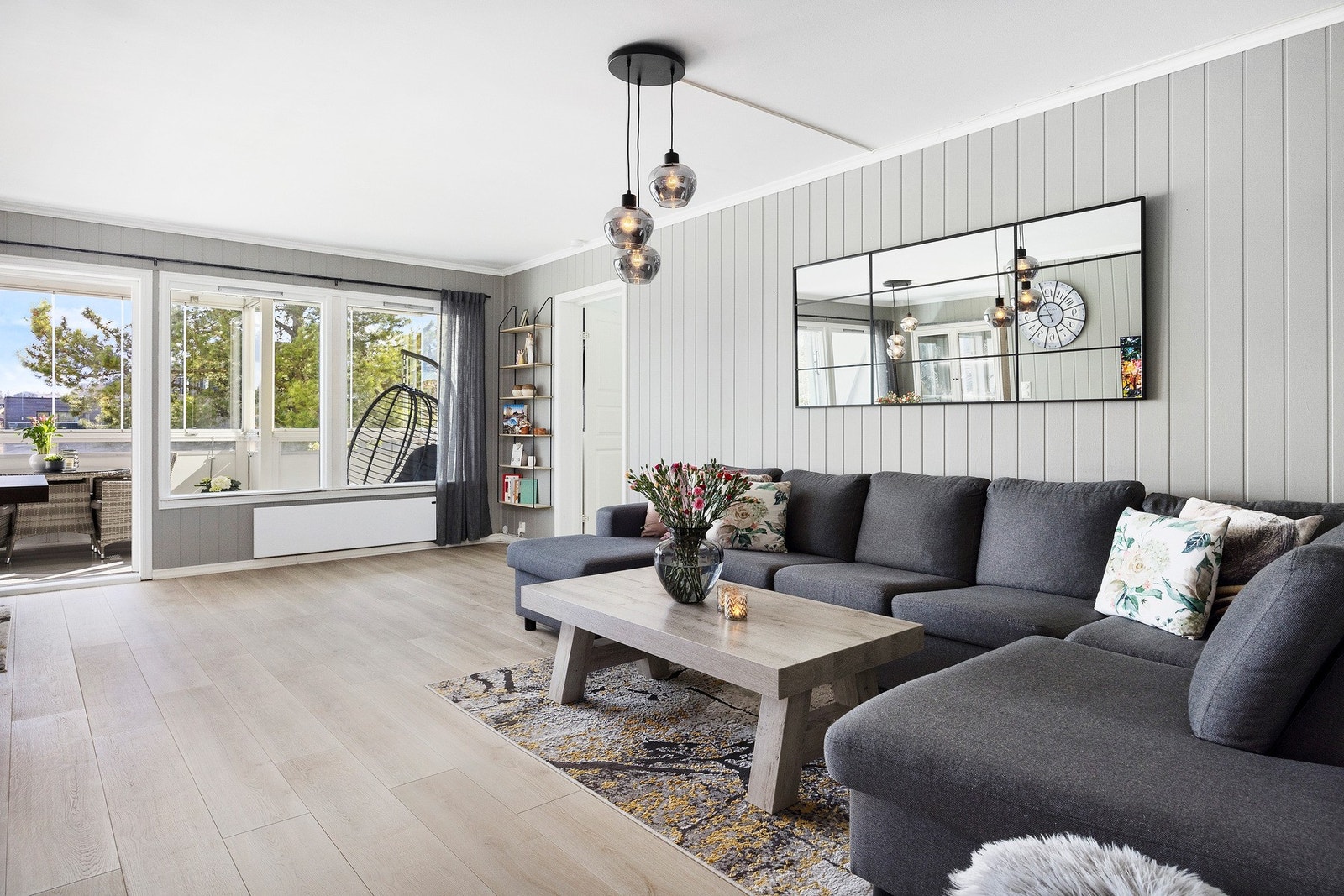 Lys og luftig stue med nytt laminatgulv fra 2023 og grå-beige vegger som skaper en lun atmosfære. Galleribilde