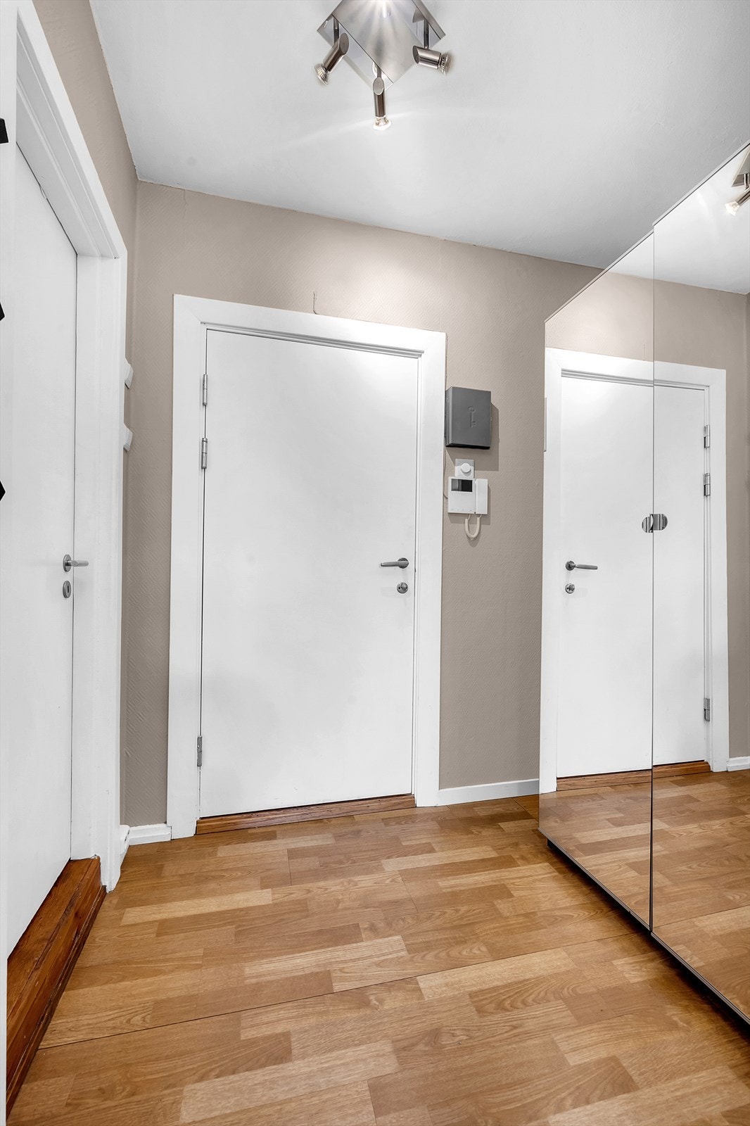 Velkommen inn! Entréen er innbydende og gir et godt førsteinntrykk av leiligheten. Her er det rom for å sette fra seg yttertøy og sko i garderobeskap. Galleribilde