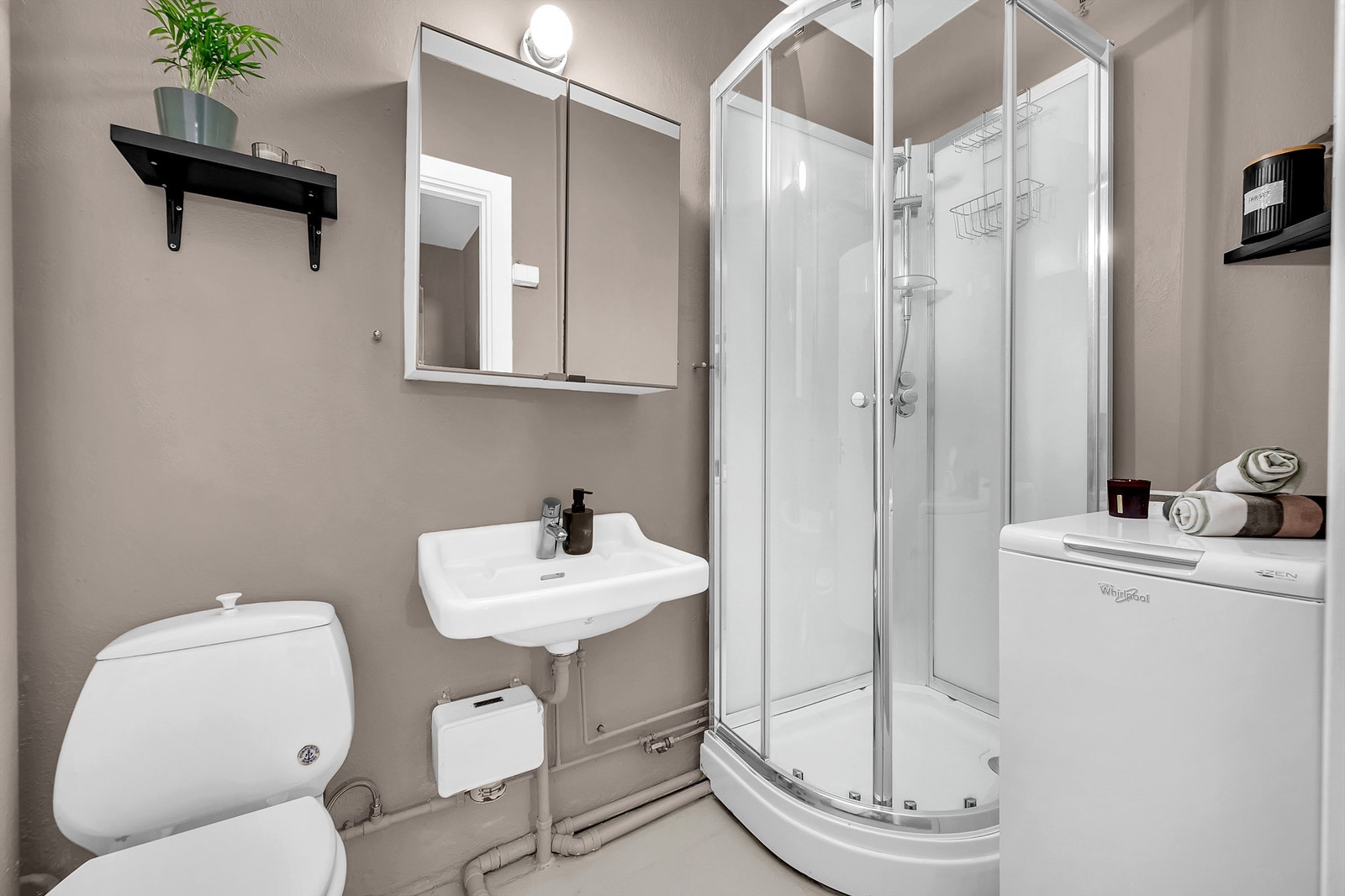 Leilighetens bad er av ukjent årstall. Flislagt gulv og vegger av malt betong. Galleribilde