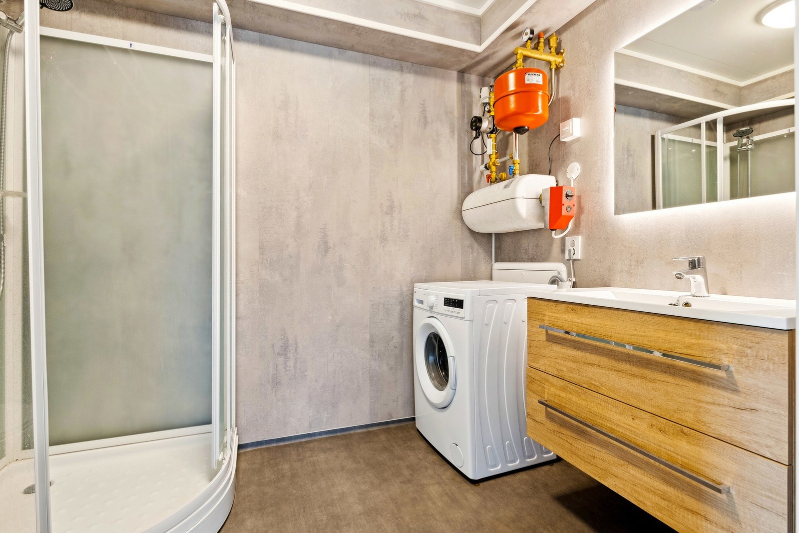 Badet har rom til det som trenger; vaskemaskin, servant, toalett og dusjkabinett. Galleribilde