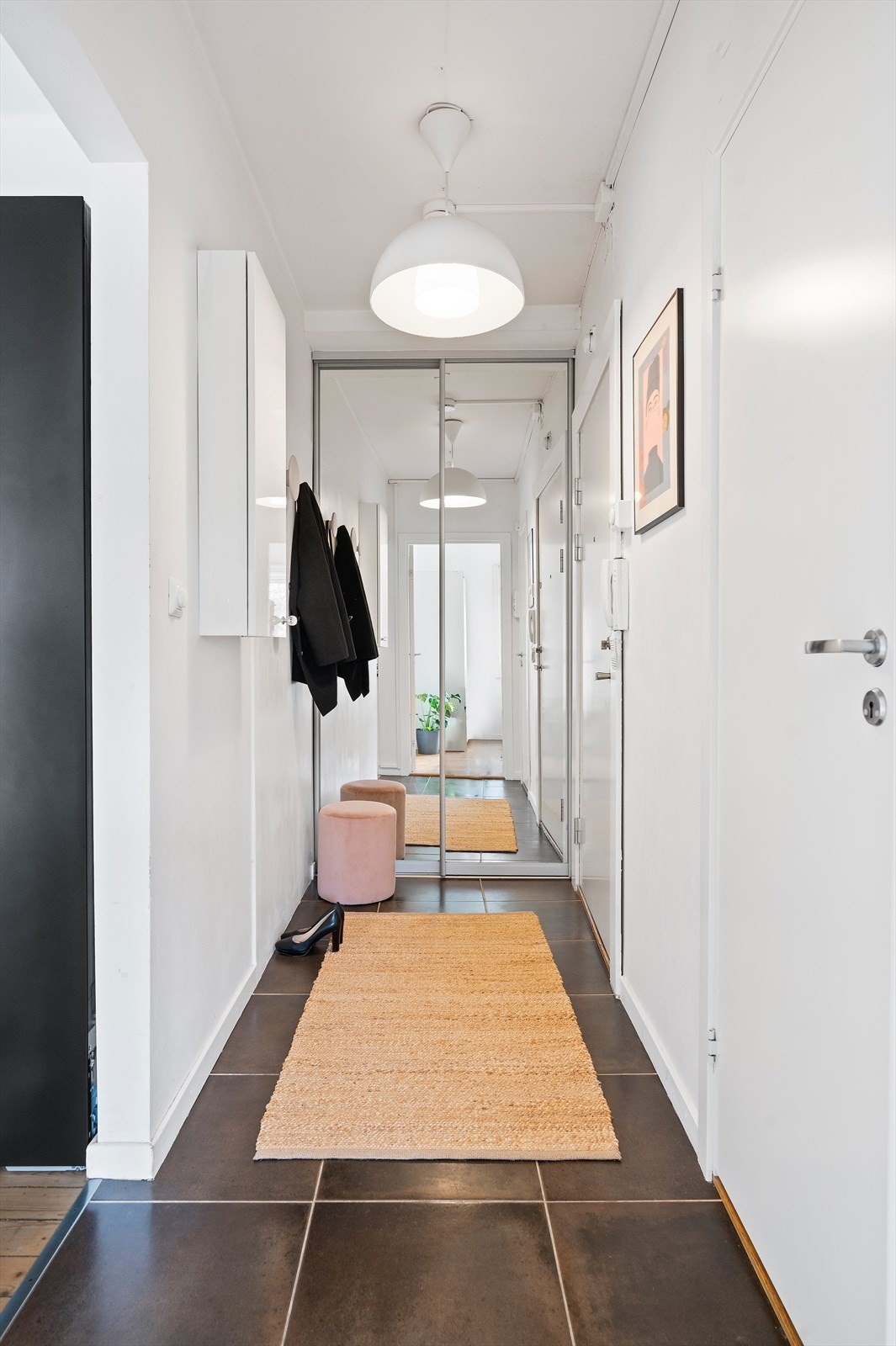 Hyggelig inngangsparti som gir et godt inntrykk av hva boligen har å by på. Det er god plass til å henge fra seg yttertøyet i en praktisk skyvedørsgarderobe med speilfronter. Galleribilde