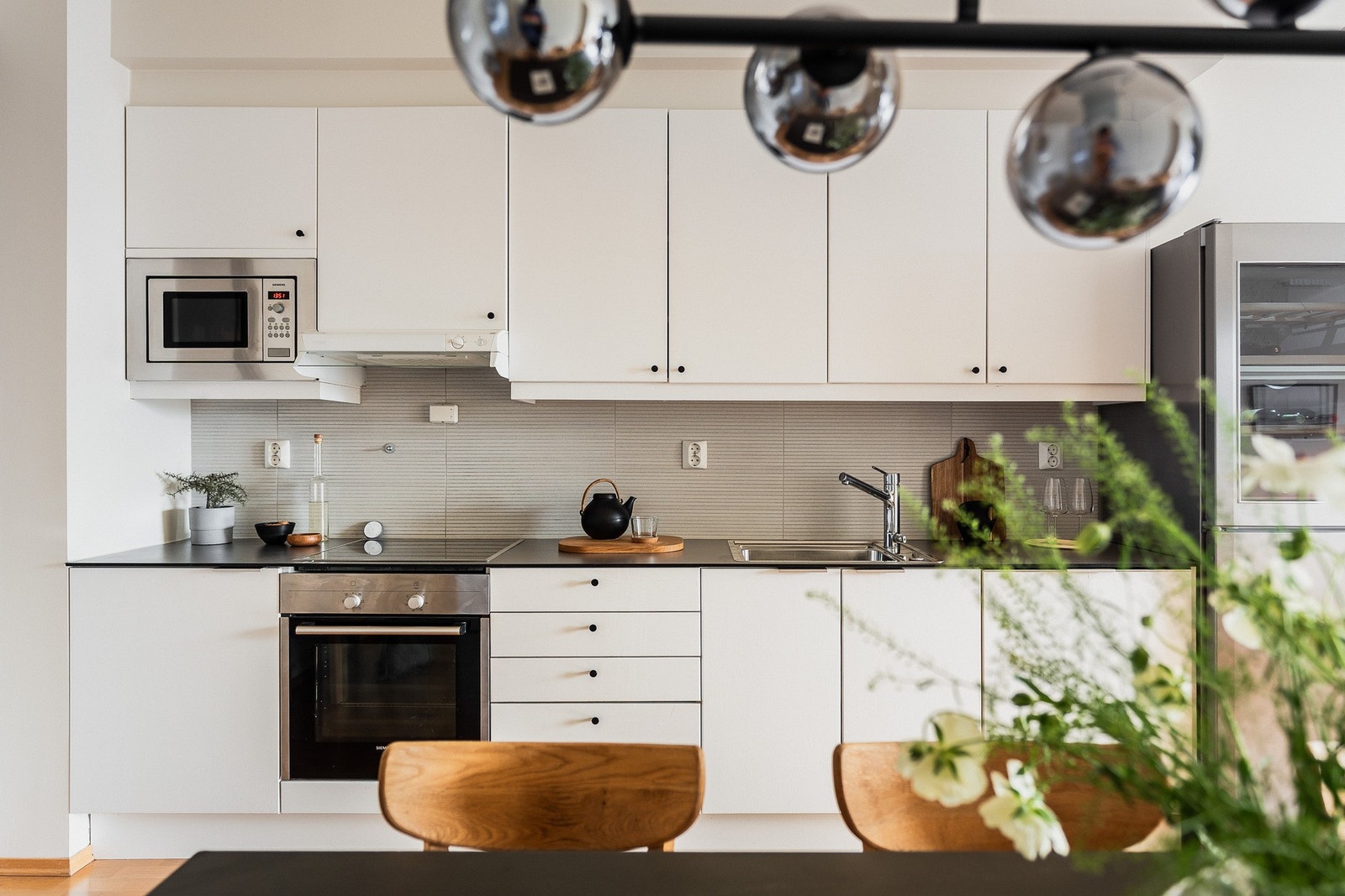 Fliser over benk og god belysning gjør det til et effektivt arbeidskjøkken, samtidig som åpen planløsning mot stue gir en luftig og hyggelig atmosfære. Galleribilde