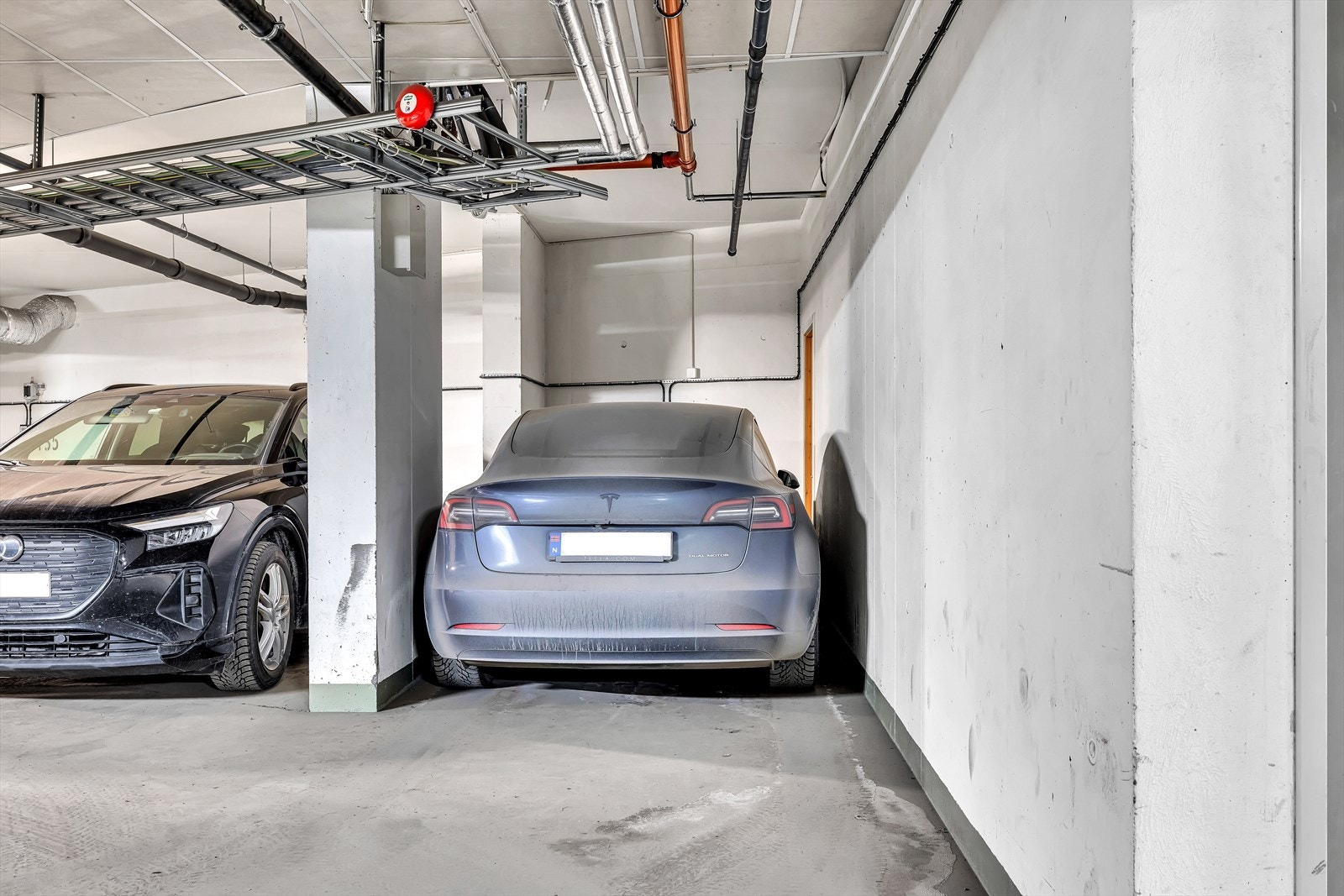 Det medfølger garasjeplass med elbillader, merket T8, i et lukket og oppvarmet garasjeanlegg. Garasjeplassen hadde et lite tomt hjørne innerst ved plassen, her har selger satt opp en lettvegg med dør, for praktisk lagring av div (dekk etc). Galleribilde