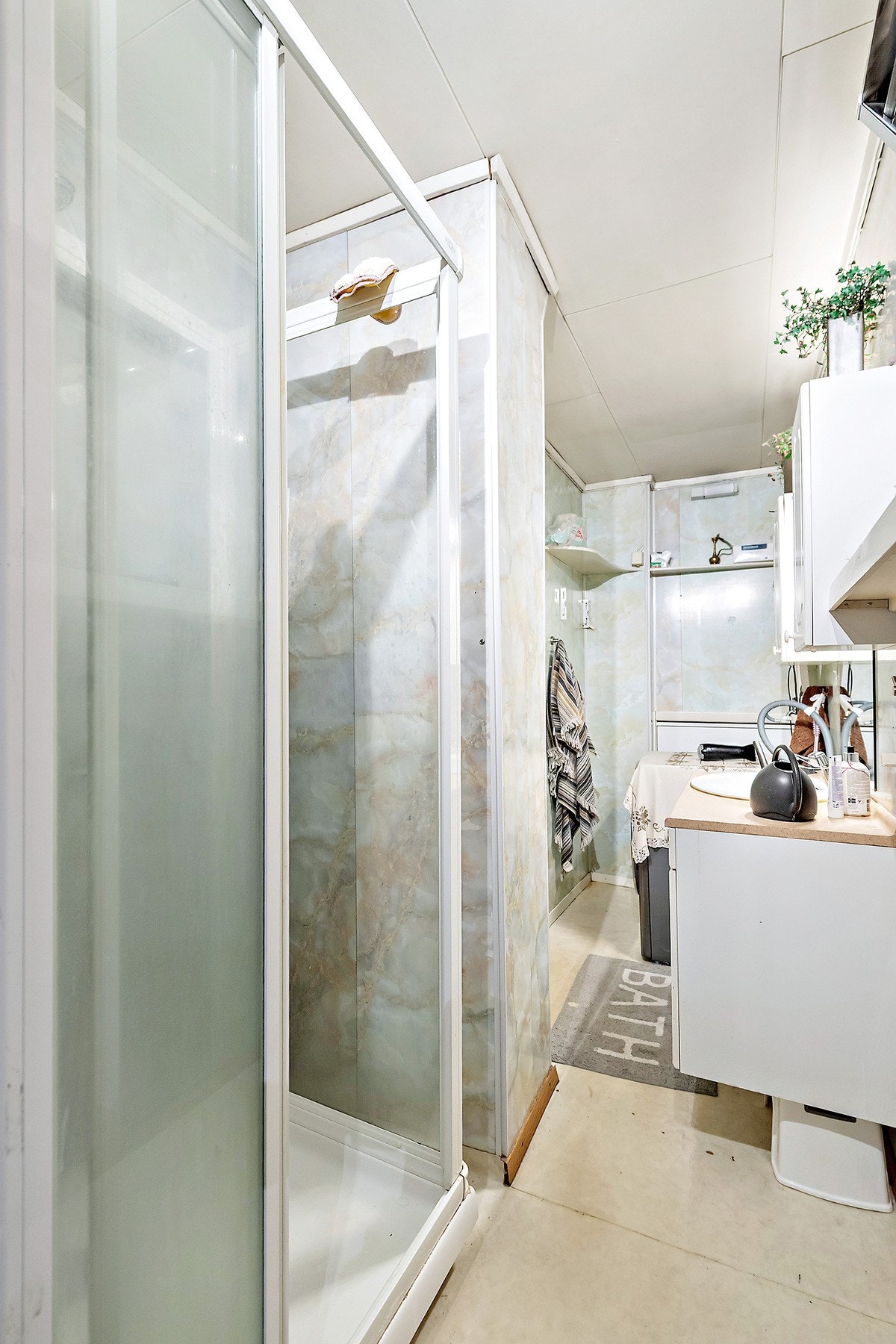 Veggvarmeovn, servantskap, gulvmontert wc, og dusjkabinett. Galleribilde