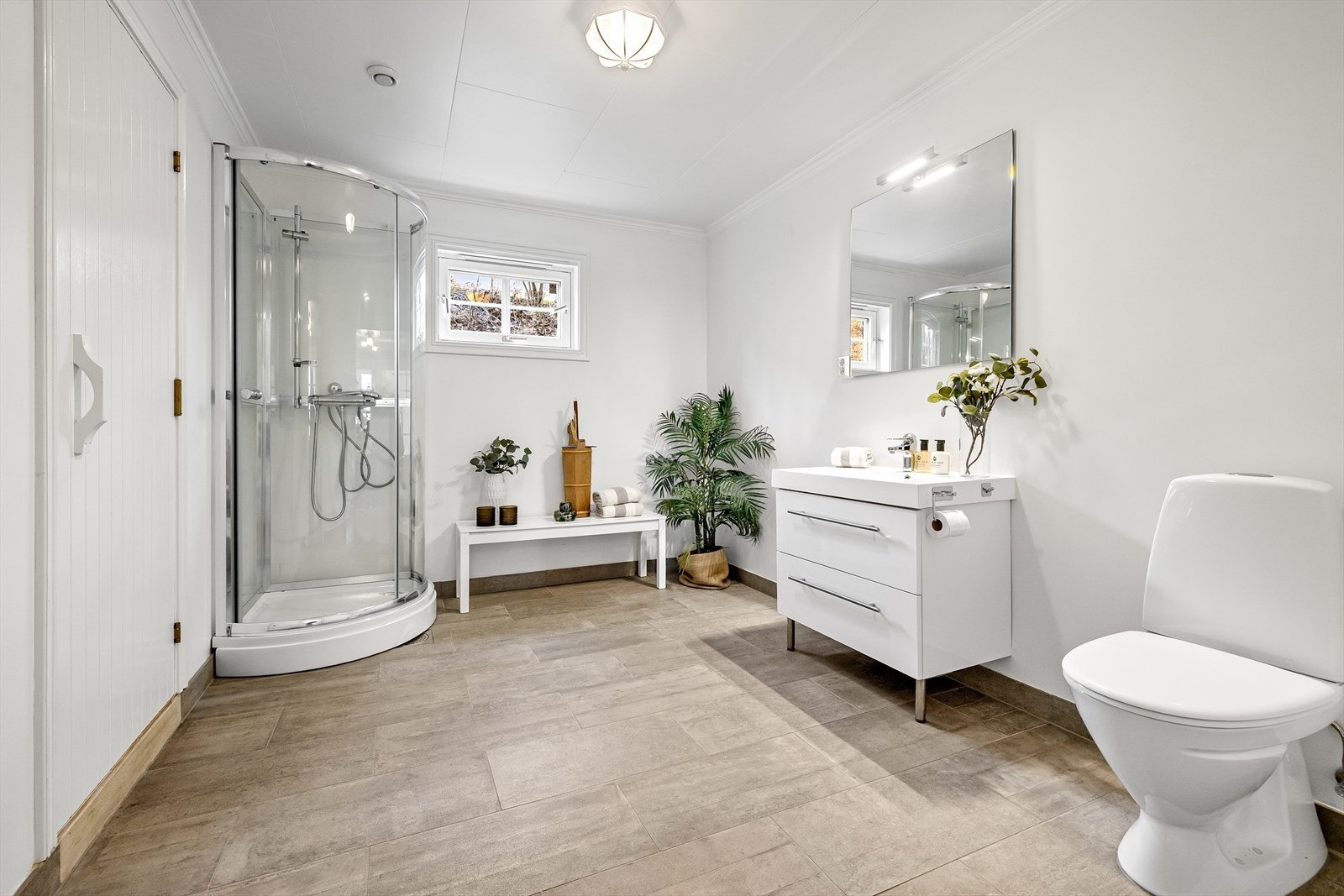 Stort bad med opplegg for boblebad. Slette malte vegger og fliselagt gulv med varmekabler. Badet ble modernisert i 2014 med flis på flis på gulv og baderomsinnredning fra samme periode. Innerst i rommet finner man et dusjkabinett og tilgang til badstuen. Galleribilde