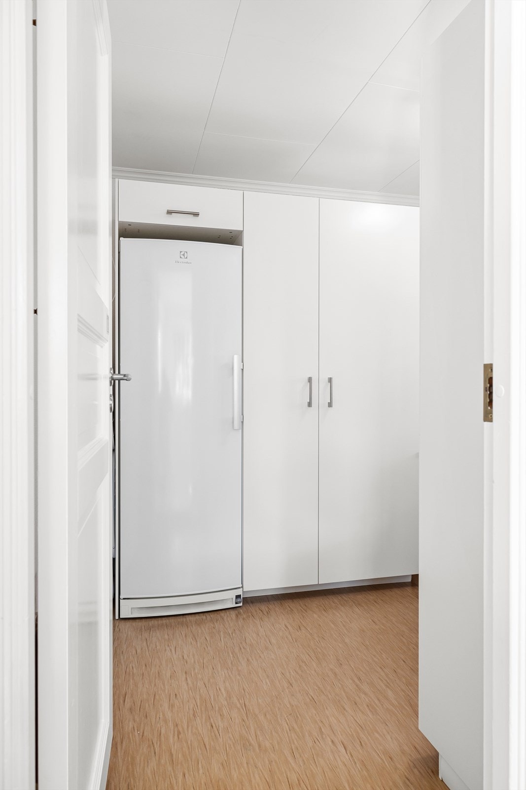 Fra kjøkkenet er det adkomst til et praktisk vaskerom med belegg på gulv, som er trukket opp på veggen og ført ned under klemringen i sluket. Galleribilde