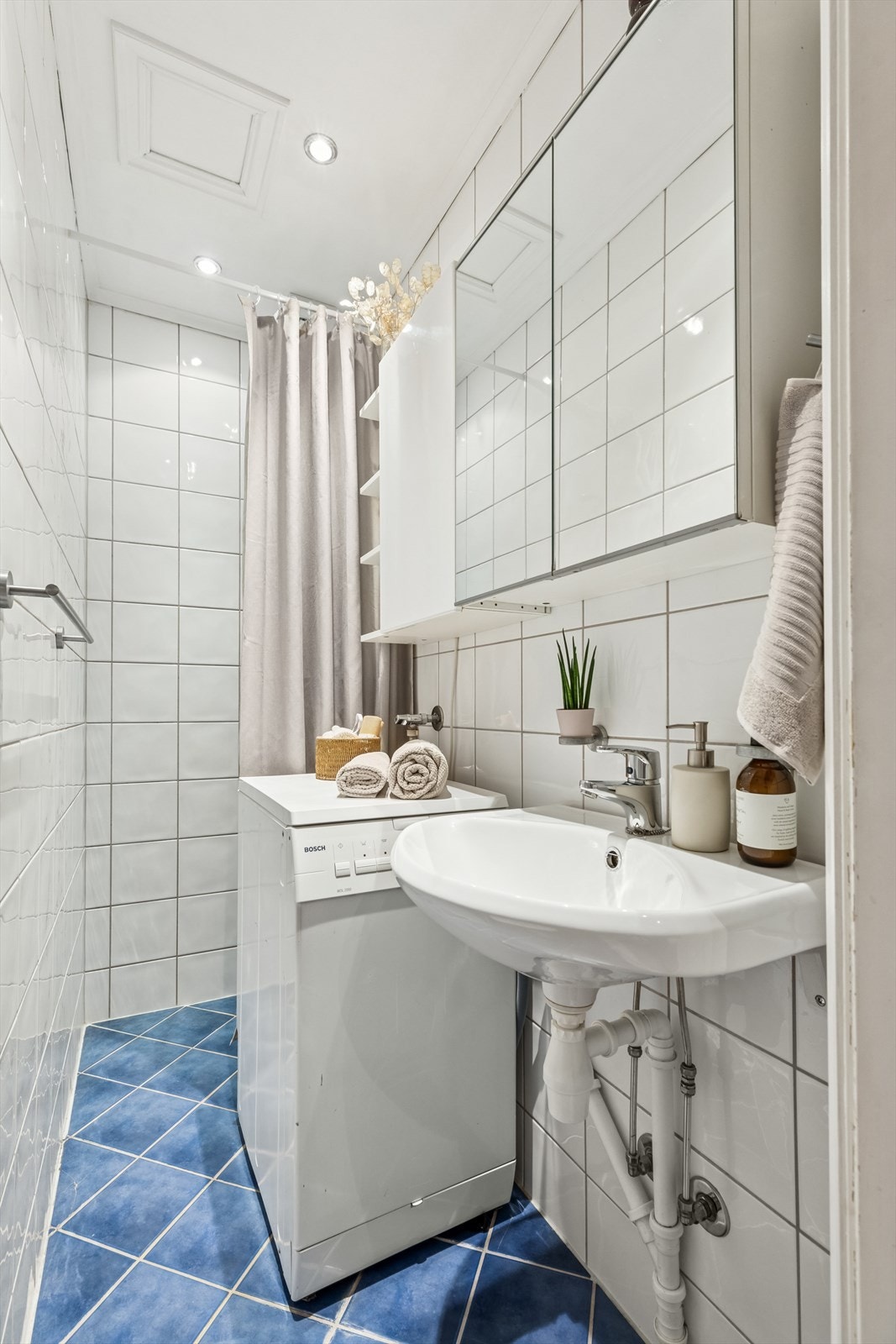 Det kombinerte badet, WC og vaskerommet har flislagt gulv med varmekabler og flis og plater på veggene. Galleribilde