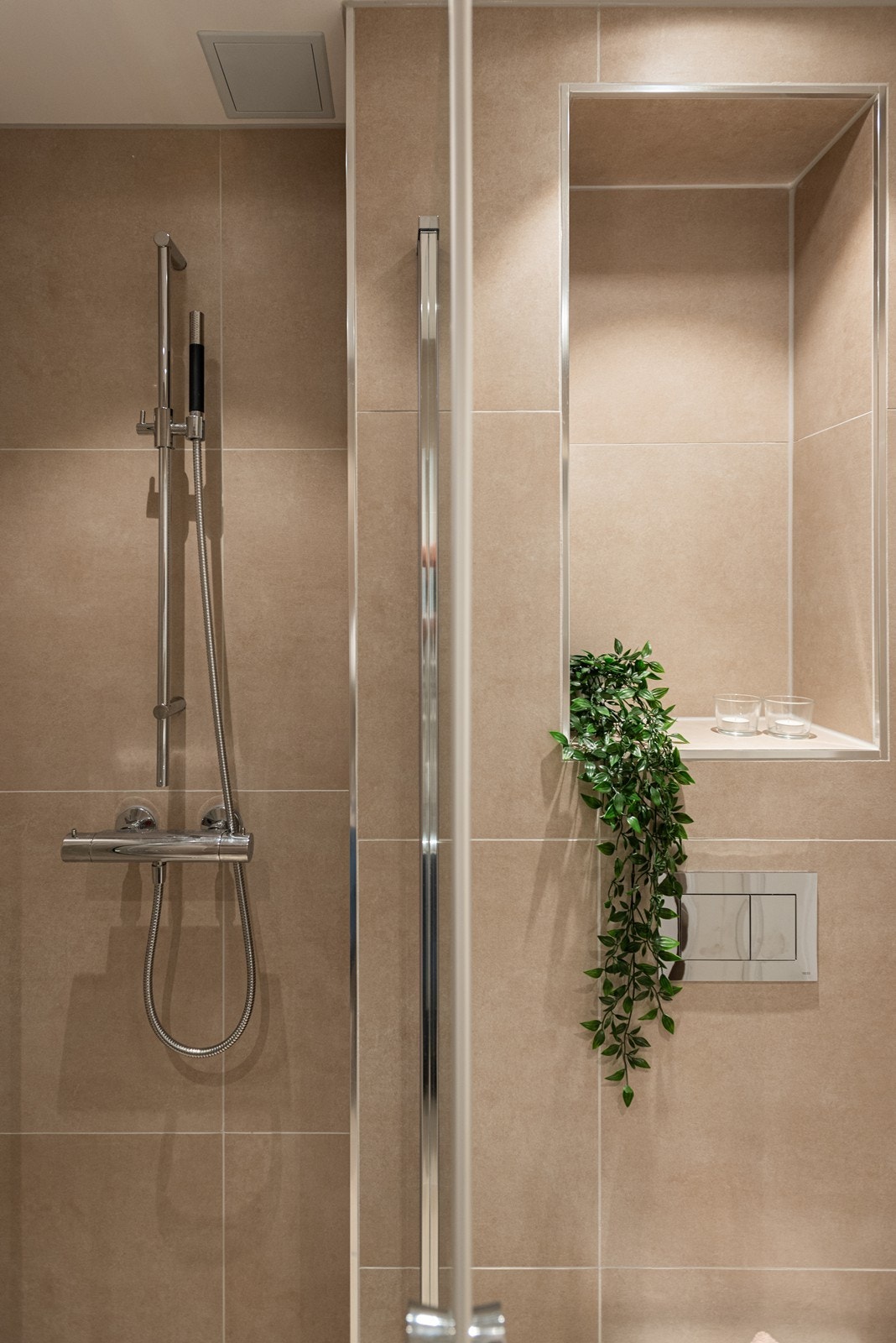 Badet er utstyrt med innfelt dusjsone, praktisk nisje og vegghengt toalett Galleribilde