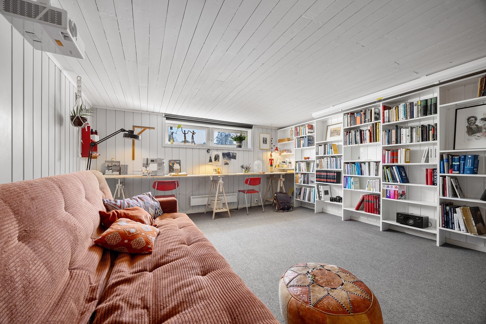 Kjellerstuen er ideelt innredet til kontorbruk med en praktisk bokhylleløsning montert på hele den ene langveggen. Galleribilde