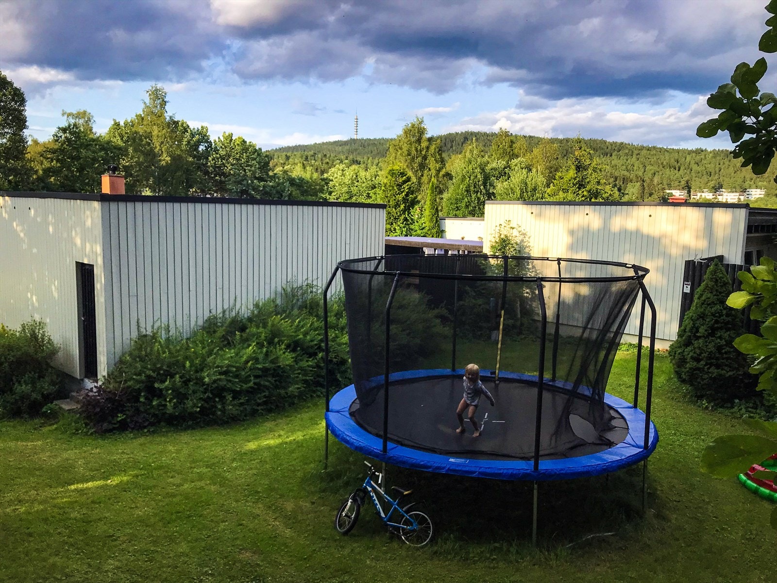 På andre siden av gjerdet er det åpent friområde og en trampoline for barna. Galleribilde