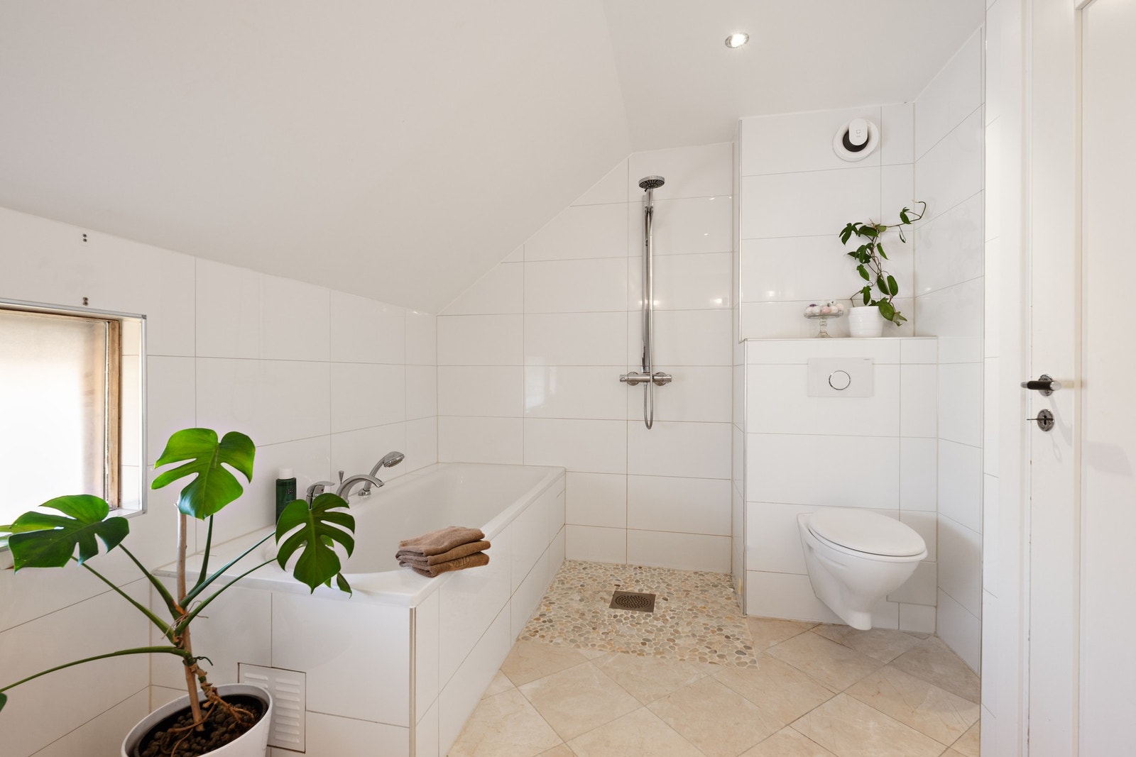 Badet har flislagte overflater, gulv med varmekabler og mosaikkfliser i dusjsonen. Praktisk baderomsinnredning med doble servanter på benkeskap, speil med belysning, samt et innfliset skap ved servant. Badet har både innfliset badekar og åpen dusjsone. Galleribilde