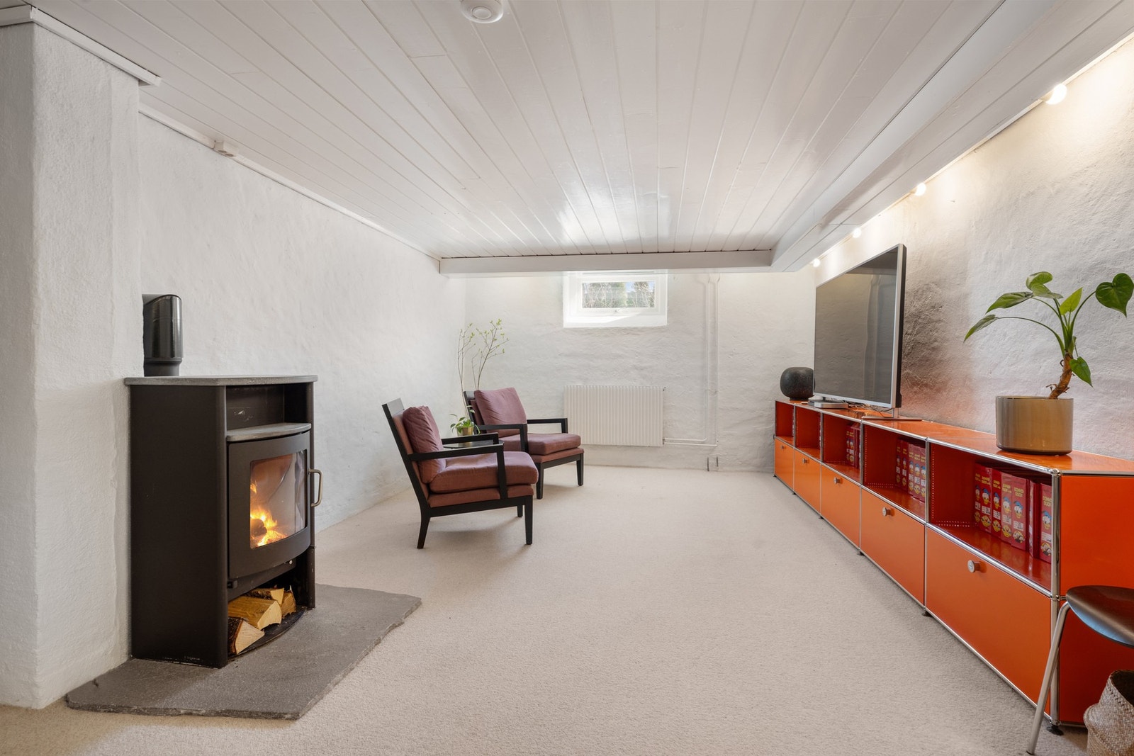 I kjelleren finner du et stort rom med peis, som i dag er innredet som TV-stue og hjemmekontor. Galleribilde