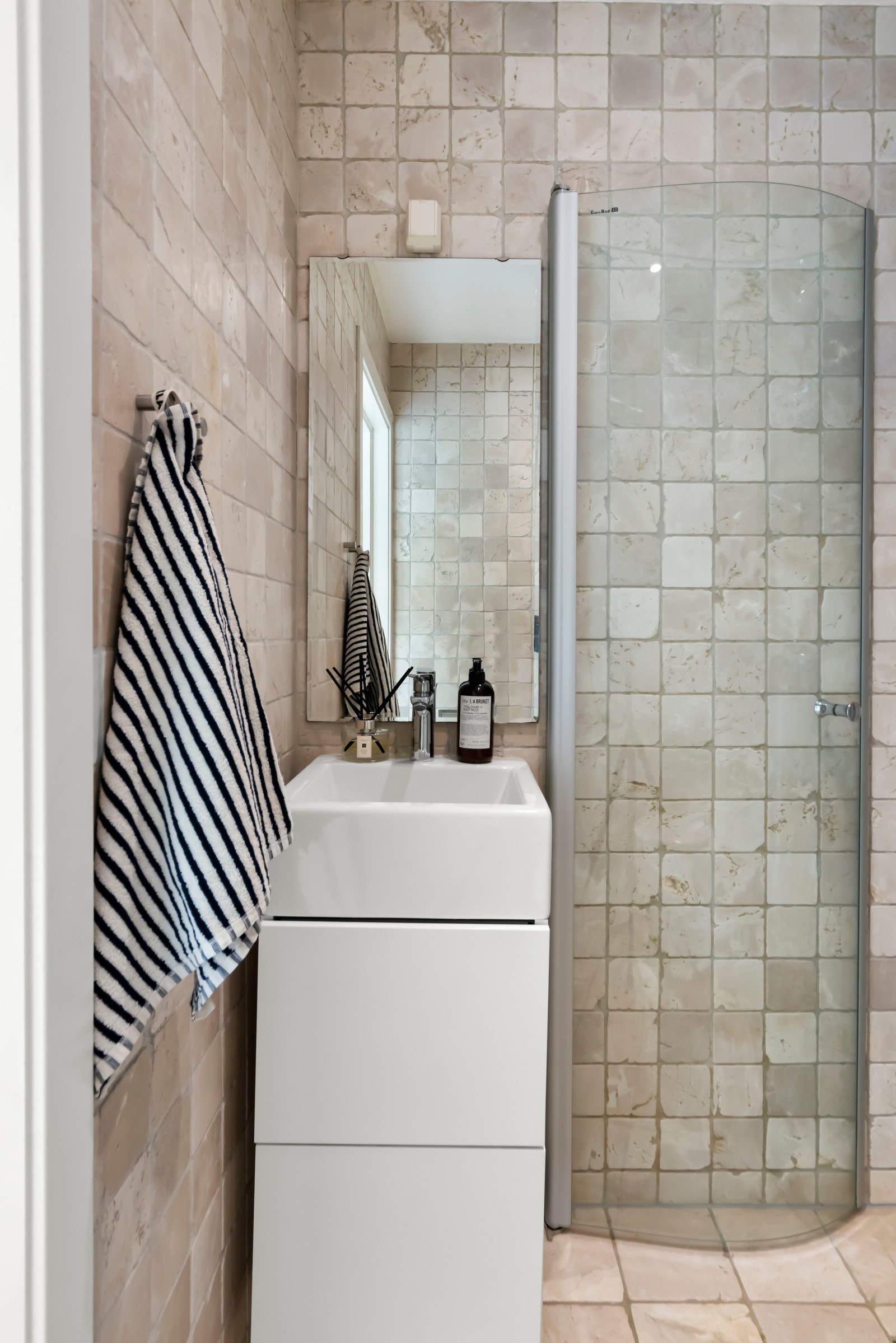 Videre har badet vegghengt toalett og dusjhjørne med svingdører i glass. Galleribilde