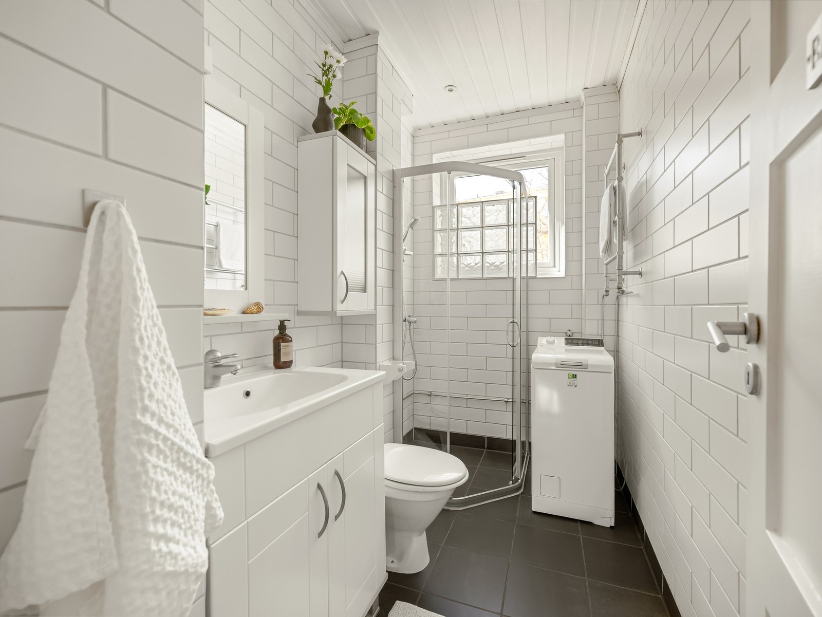 Badet er innredet med dusjhjørne, servant med skapinnredning og veggskap. Det er varme i gulvet og downlights i himling. Galleribilde