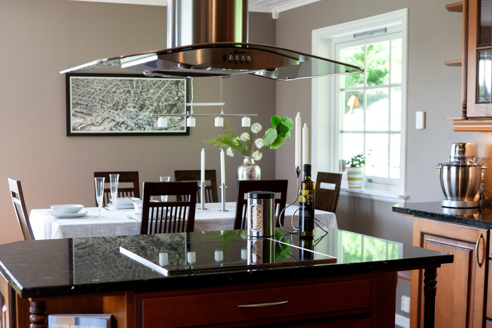 Med skreddersydde skap i varm trefinish og benkeplater i Larvikitt, kombinerer kjøkkenet robust kvalitet med funksjonalitet. Galleribilde