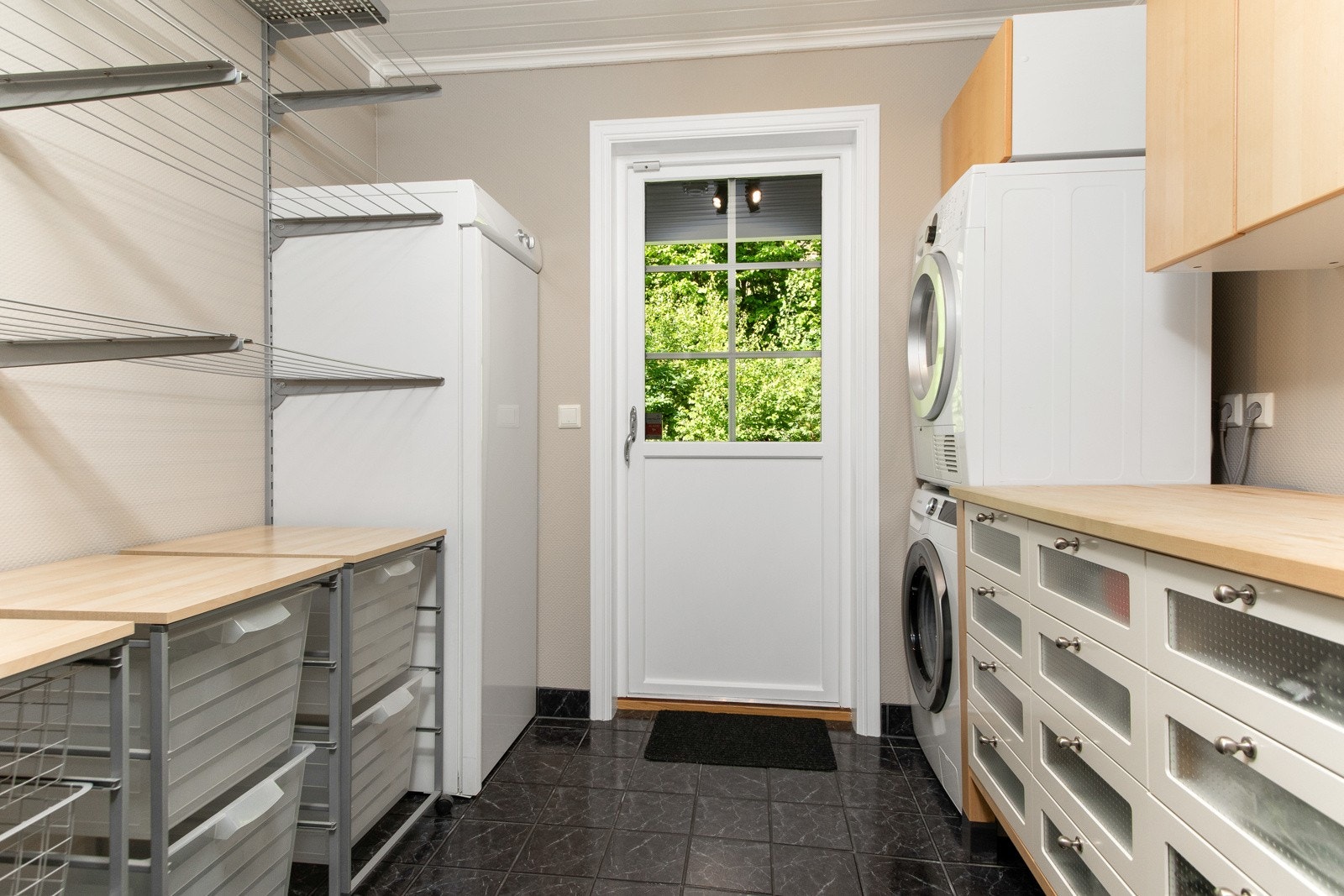 Vaskerommet ligger vegg-i-vegg med badet og har fliset gulv og slette vegger. Herfra er det også en egen utgangsdør til bakhagen Galleribilde