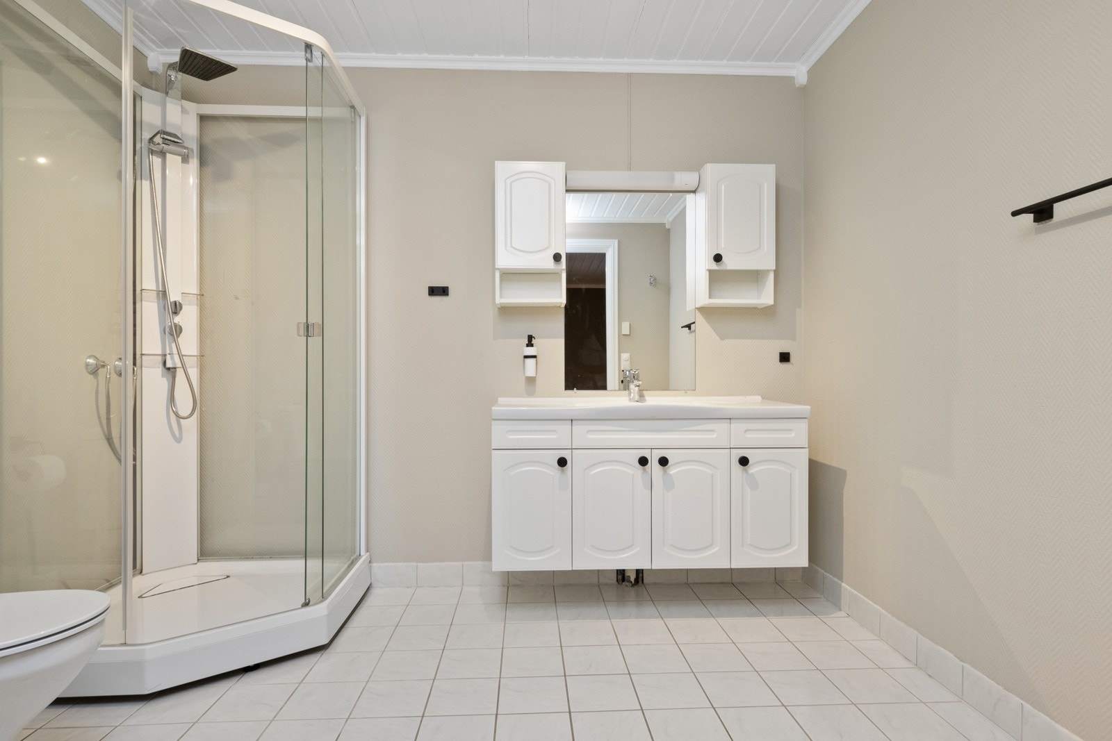 Badet har dusjkabinett og opplegg for vaskemaskin og tørketrommel. Galleribilde